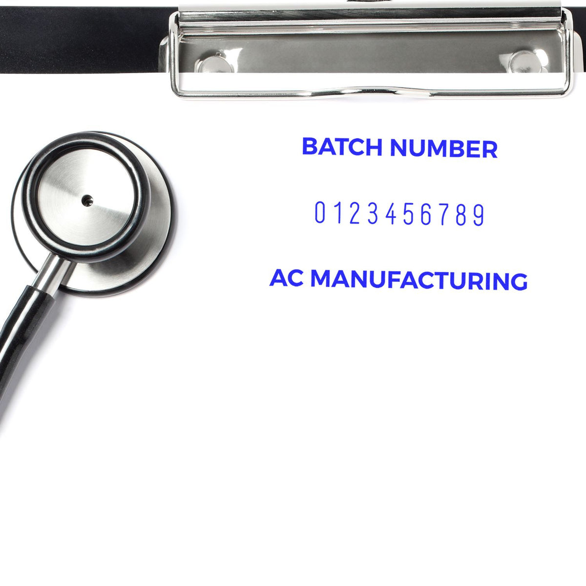Metal batch-number stamp and seal tool on white sheet, with blue text, silver clip, and black handle.