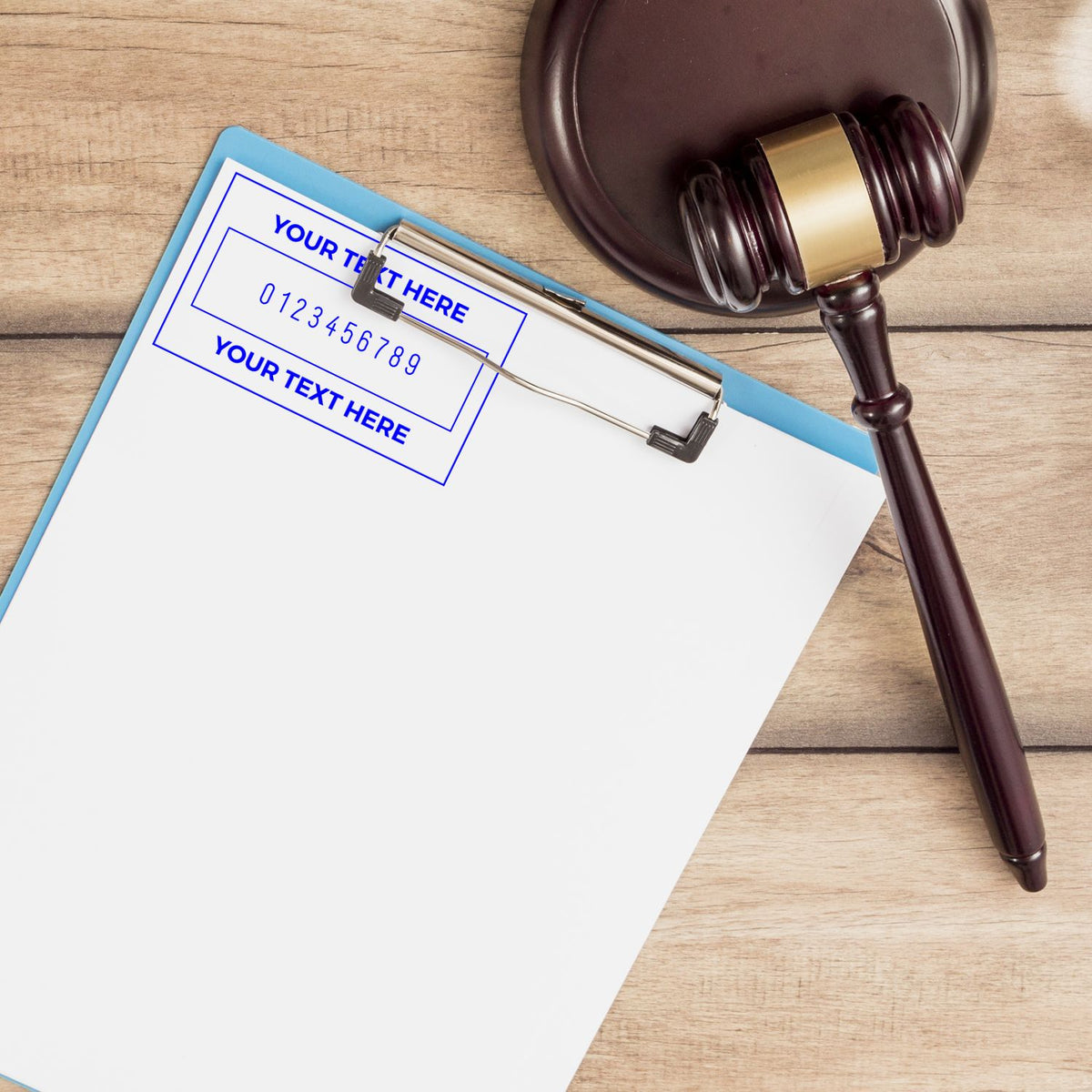 Dark wood gavel and brass seal stamp on a blue clipboard with customizable text fields over a wood desk