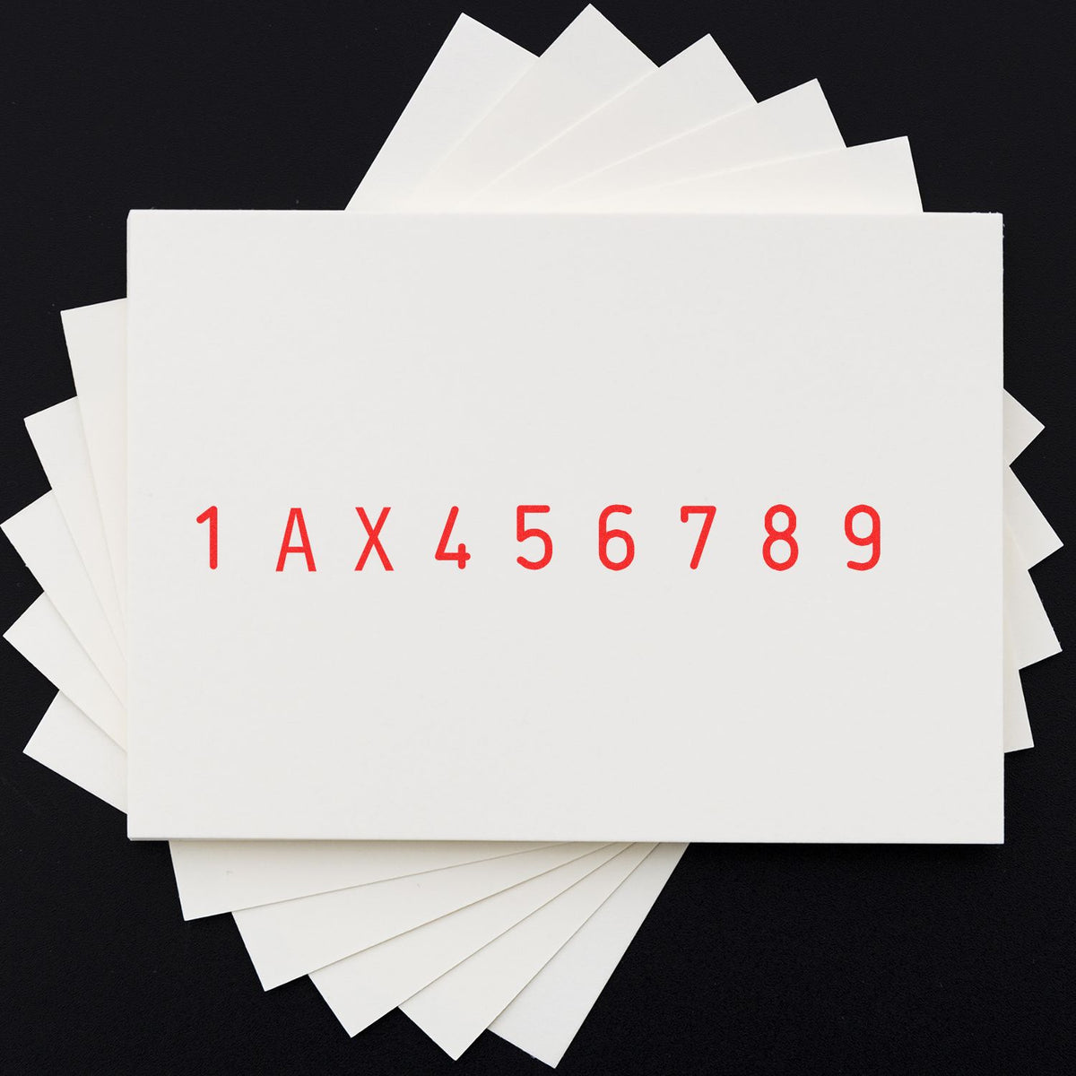 White stamp and seal sample cards with red 1AX456789 imprint on a black background.