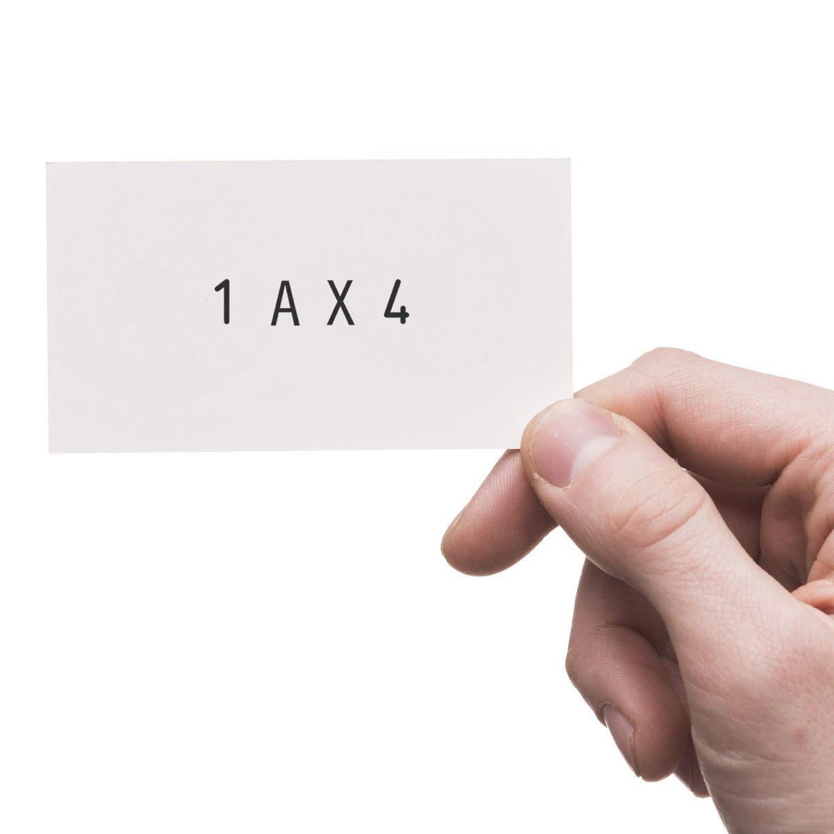 Hand holding a white stamp sample card for seal products, marked 1AX4 in black.