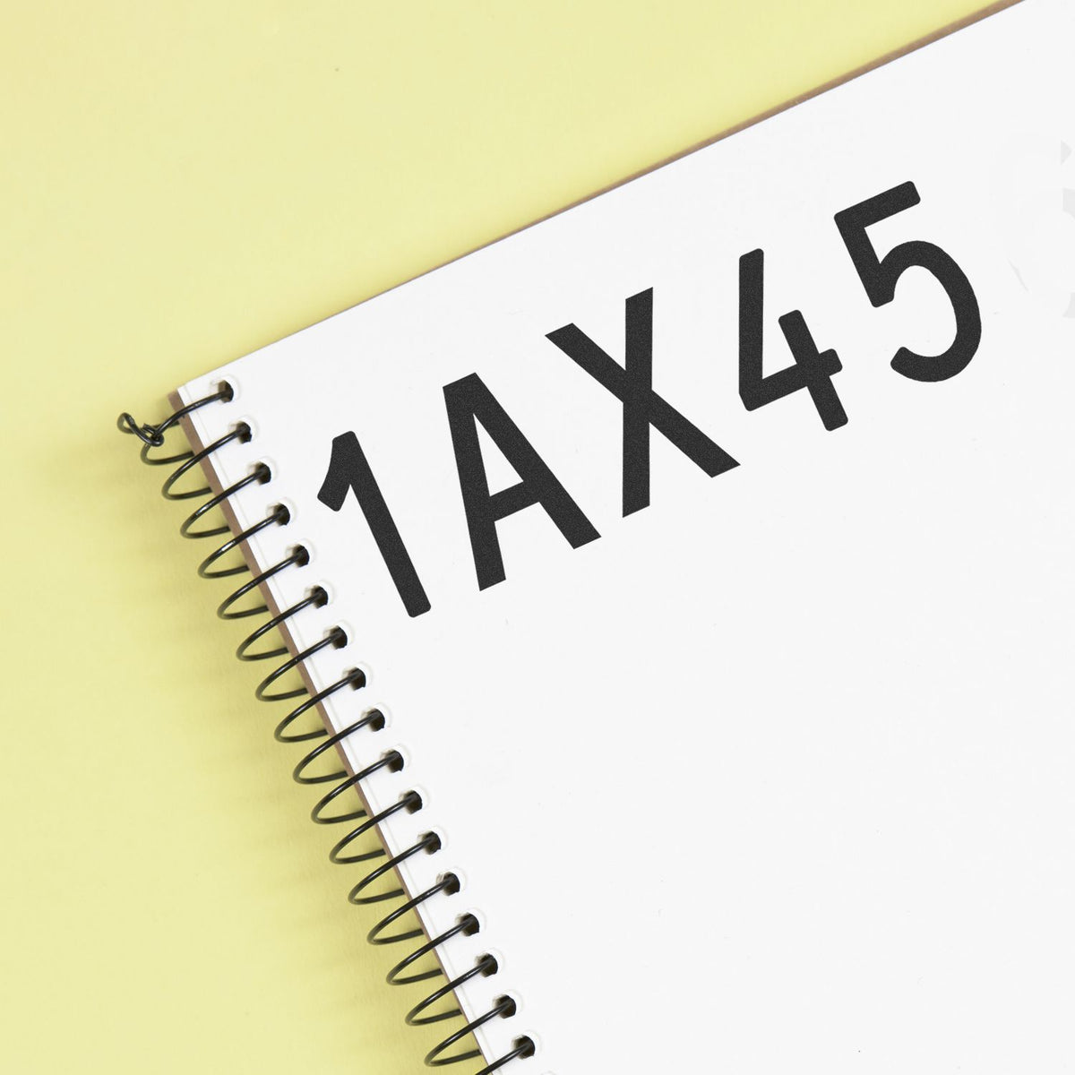White spiral-bound stamp and seal notebook with bold black 1AX45 text on pale yellow background.