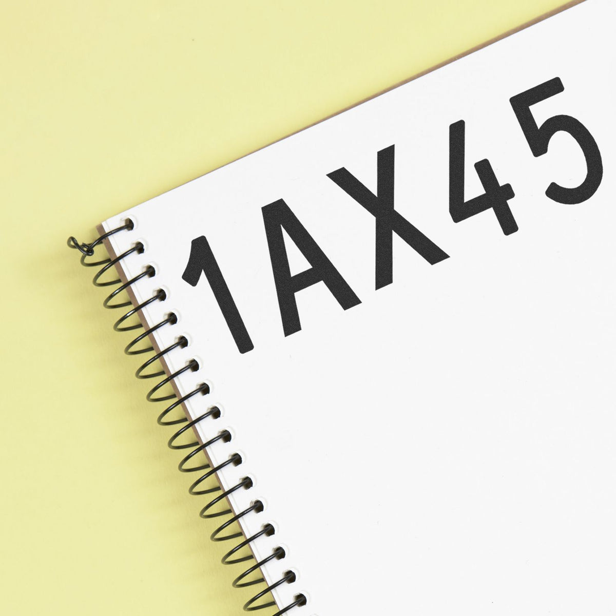 White spiral-bound stamp and seal product with bold black 1AX45 text on a pale yellow background.