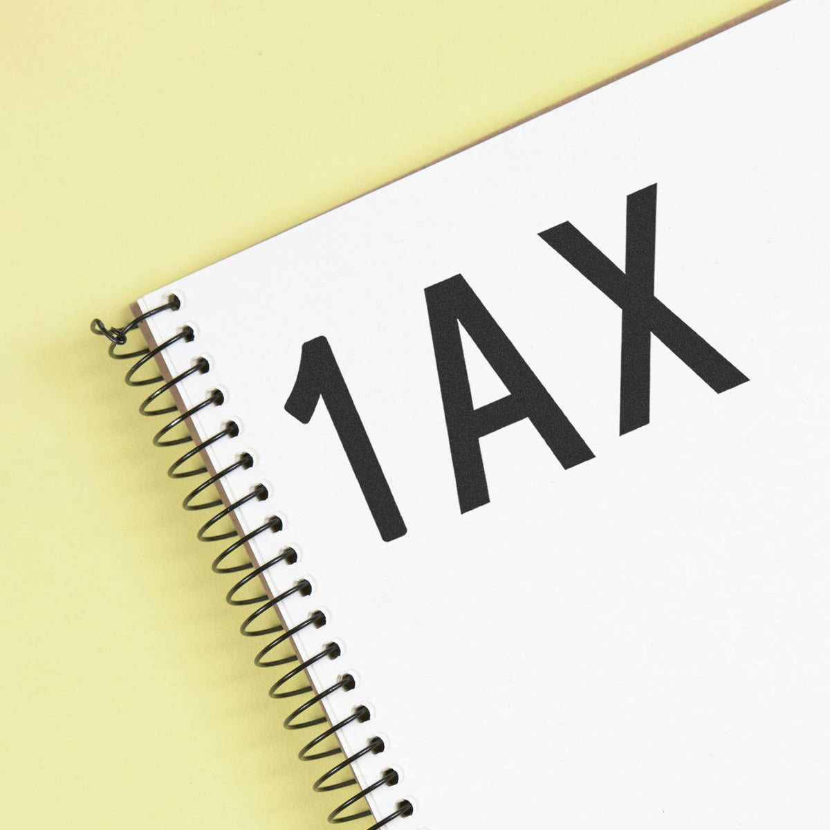 White spiral-bound stamp and seal product with bold black 1AX lettering on a pale yellow background.