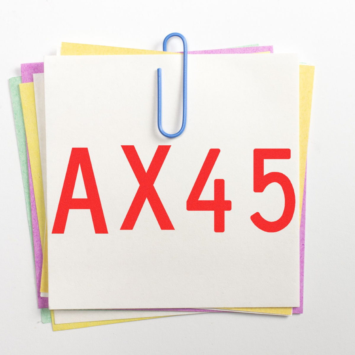 AX45 red stamp seal on stacked pastel paper cards, clipped with a blue paperclip