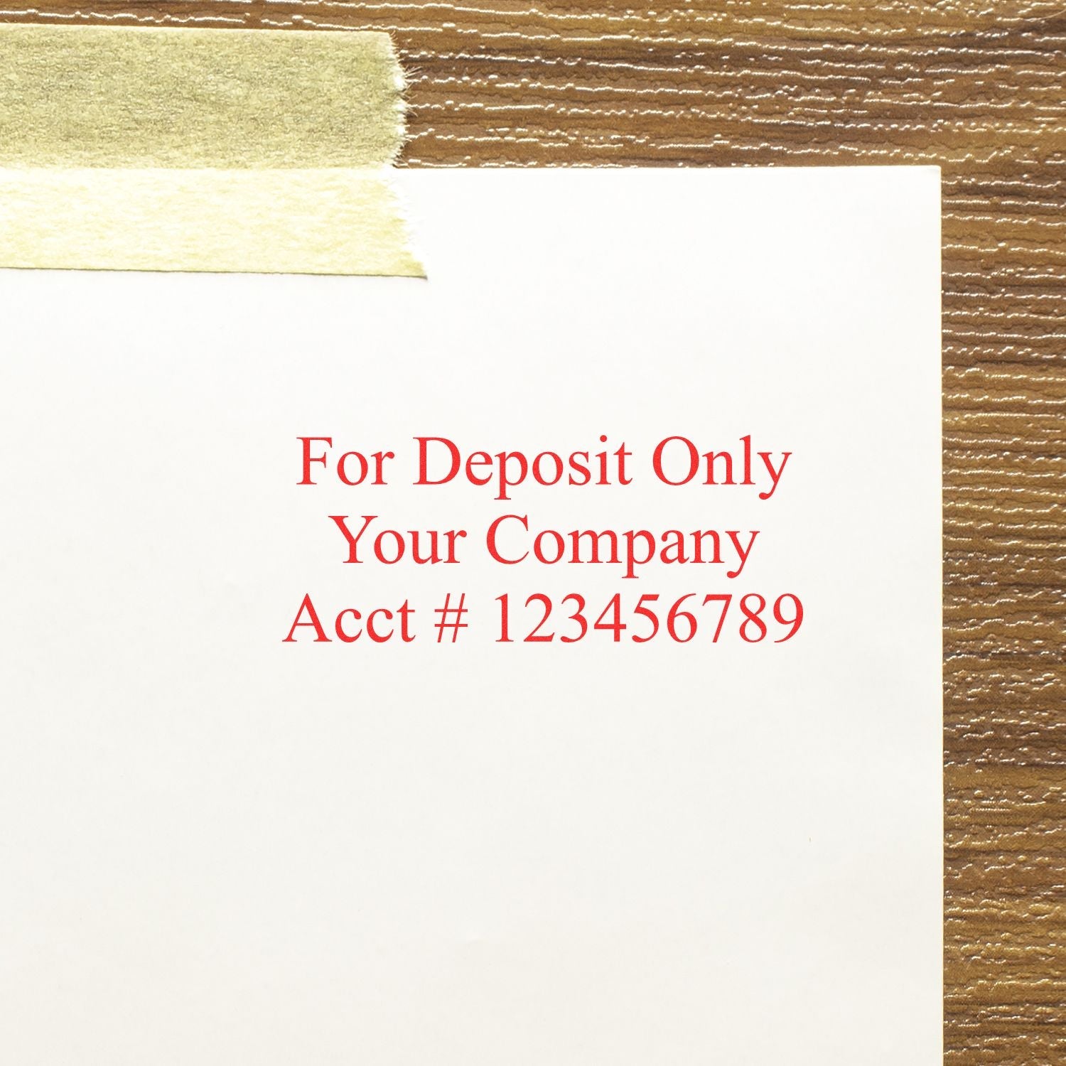 3 Line Self Inking Check Endorsement Stamp in red ink on white paper, reading For Deposit Only Your Company Acct # 123456789 on a wooden surface.