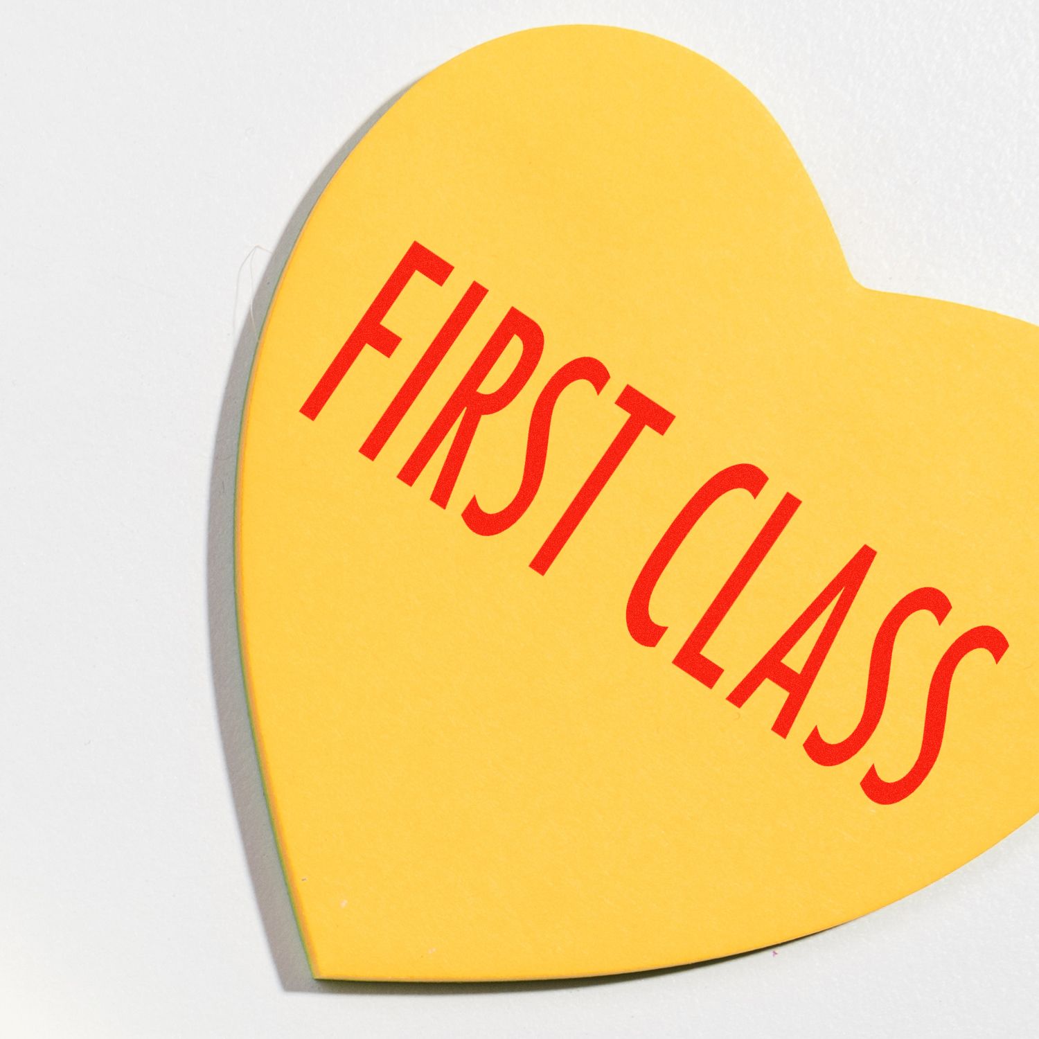 Yellow heart-shaped Large Pre-Inked First Class Stamp with red FIRST CLASS text on a white background.