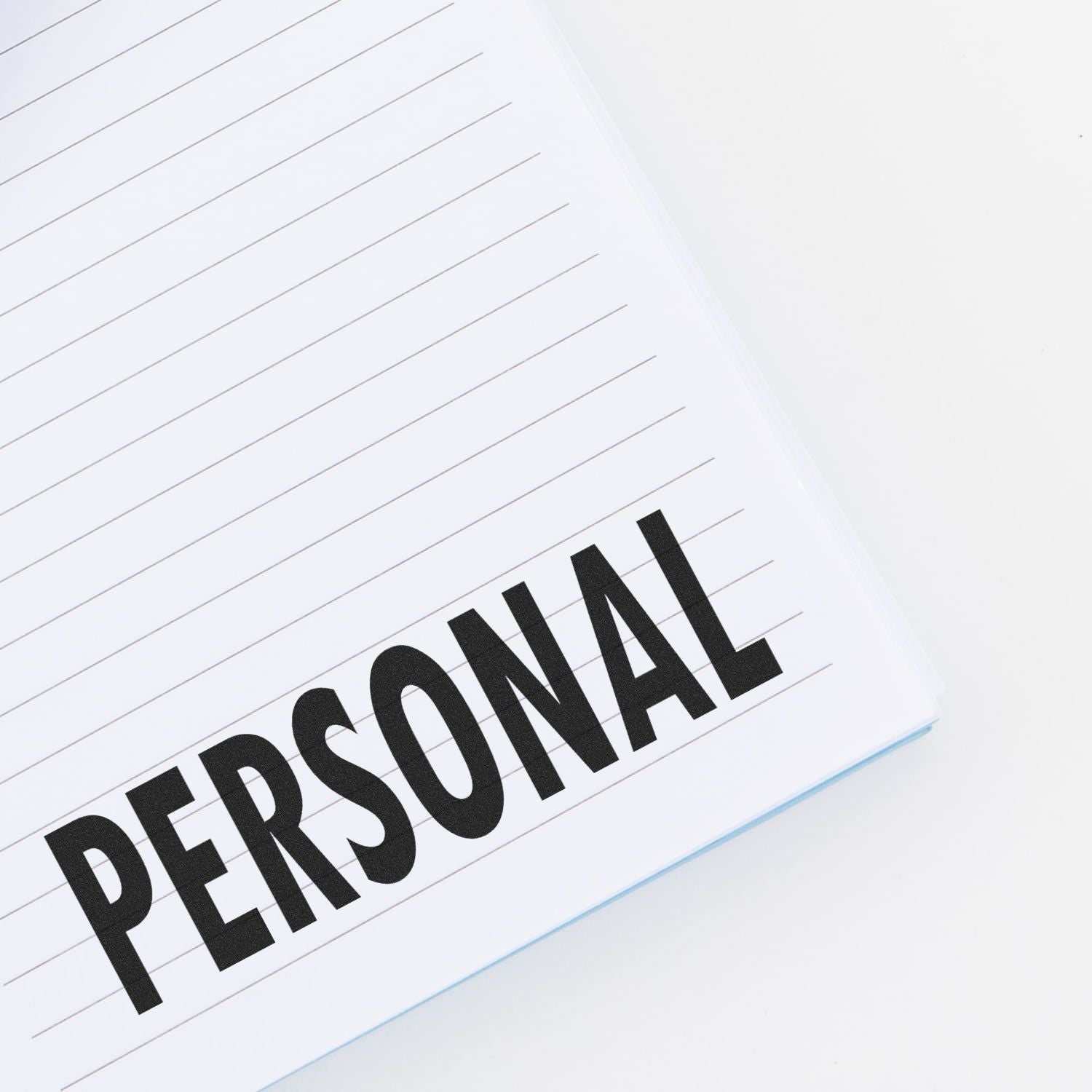 A notebook with lined pages stamped with the word PERSONAL using the Large Pre-Inked Personal Stamp.