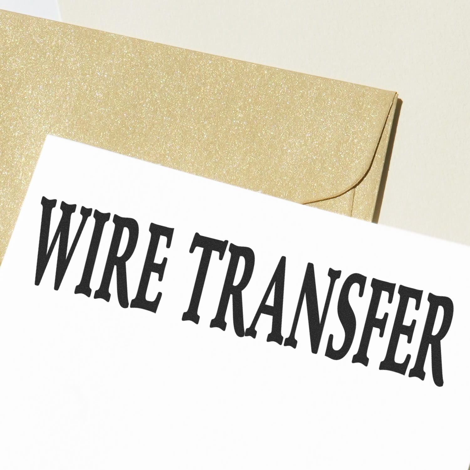 Large Pre-Inked Wire Transfer Stamp imprint on white paper with a gold envelope in the background.