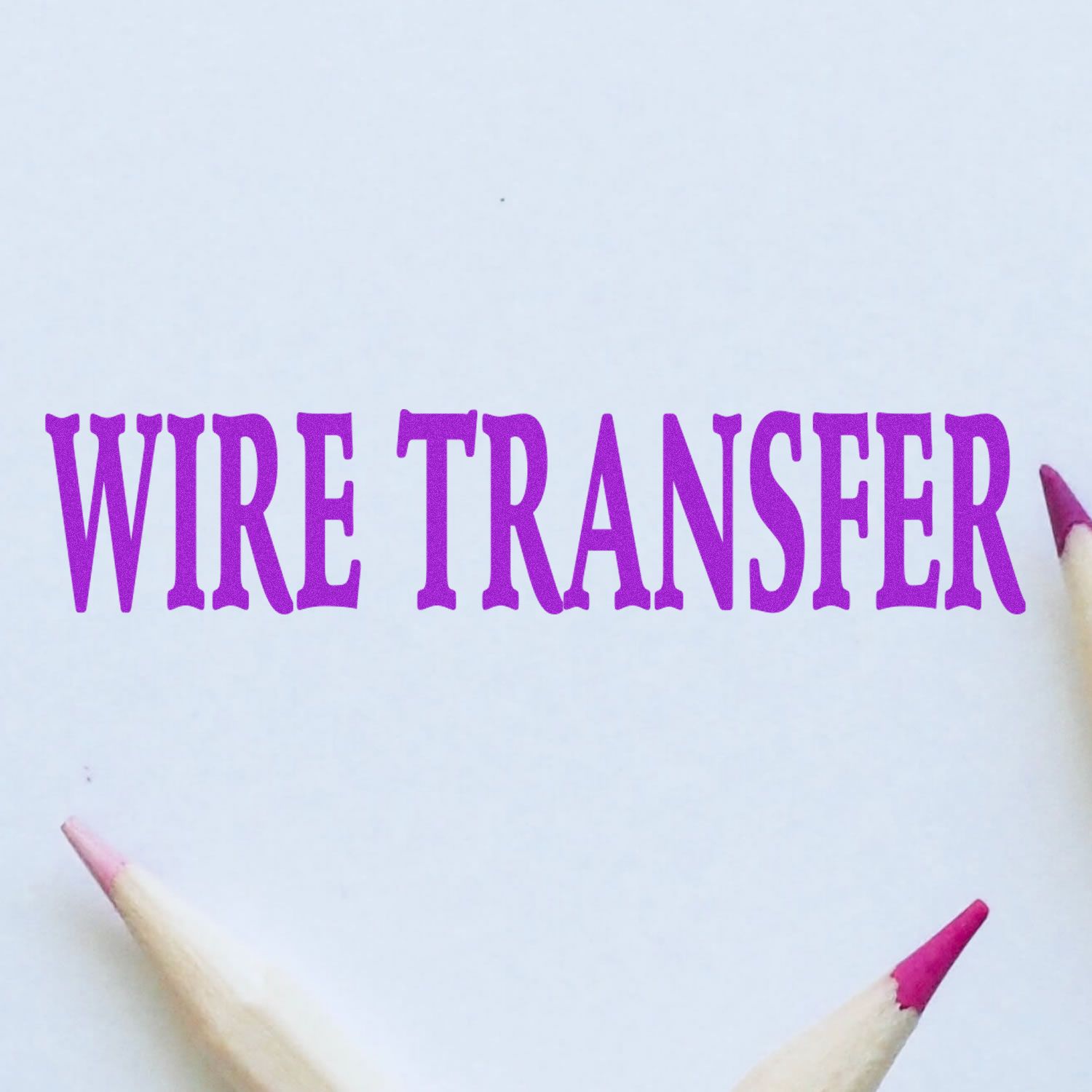 Large Pre-Inked Wire Transfer Stamp in purple ink on white paper, surrounded by three pencils with pink tips.