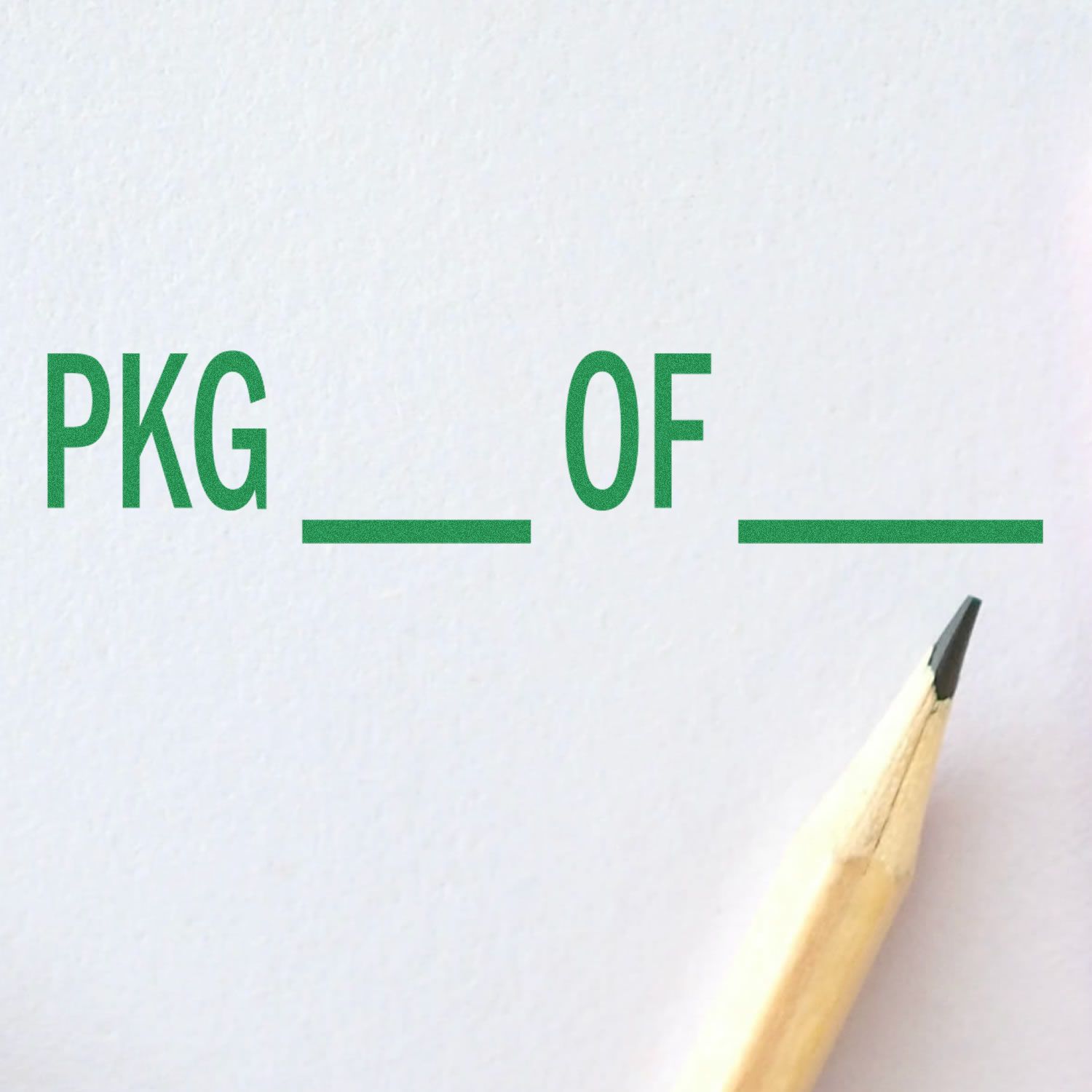 Large Pre-Inked Pkg Stamp with green text PKG OF on white paper, next to a sharpened pencil tip.