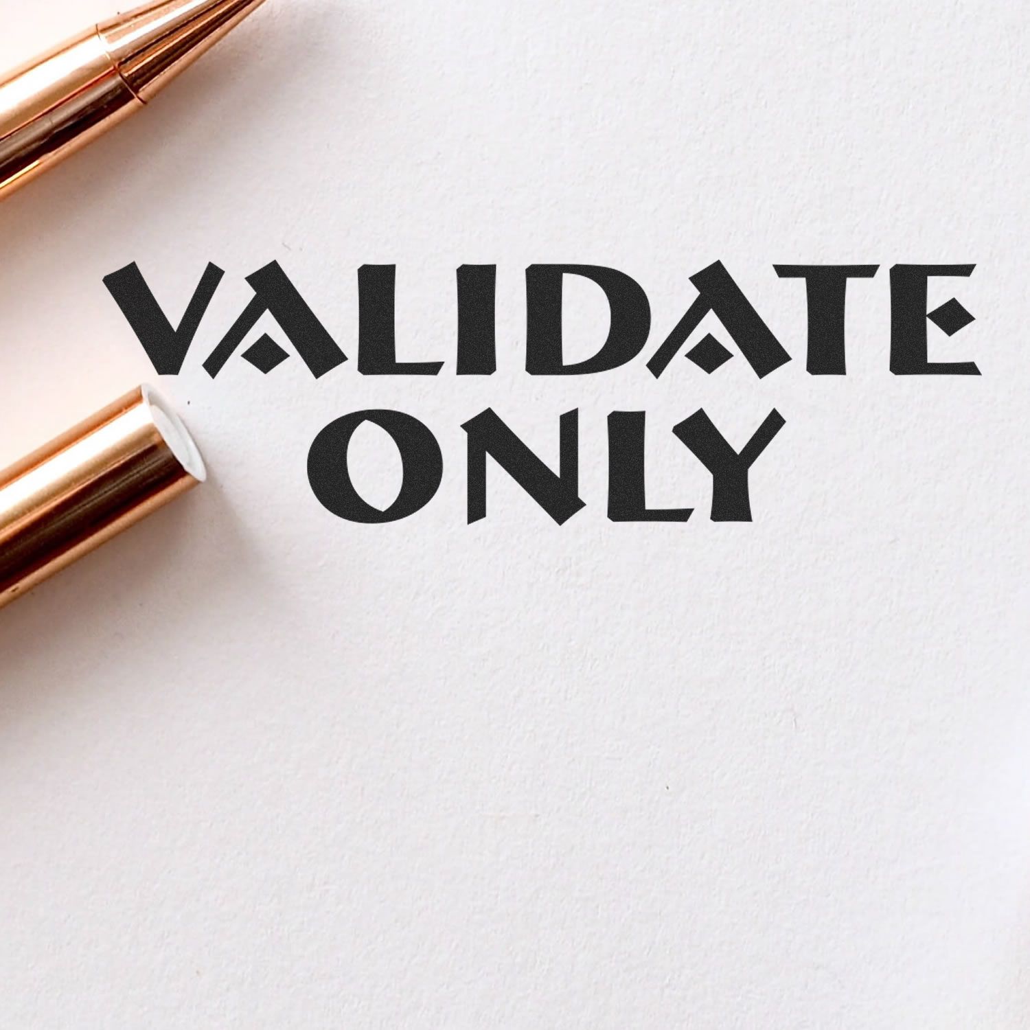 Large Pre-Inked Validate Only Stamp imprint on white paper, with a gold pen beside it.