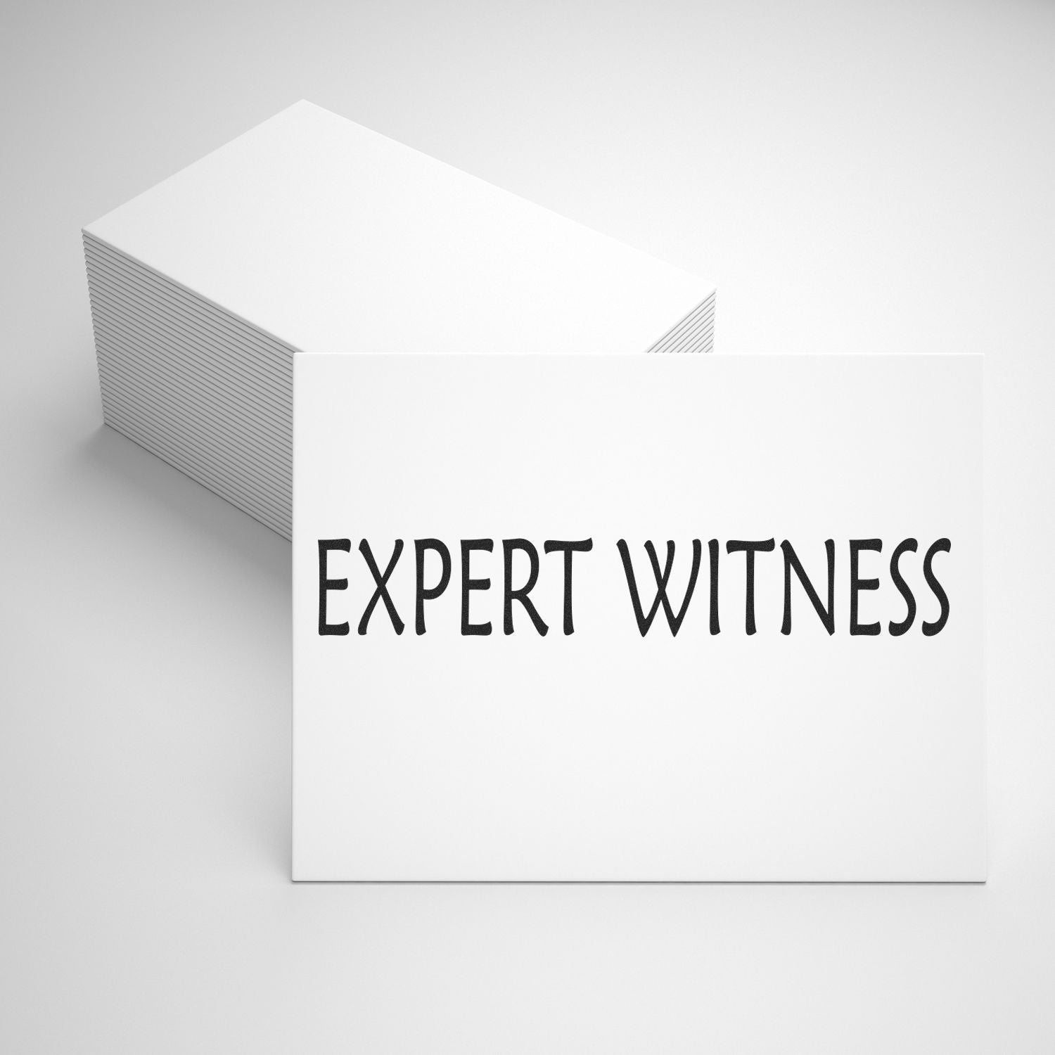 A stack of white cards with EXPERT WITNESS stamped in black using the Large Pre-Inked Expert Witness Stamp, placed on a white surface.