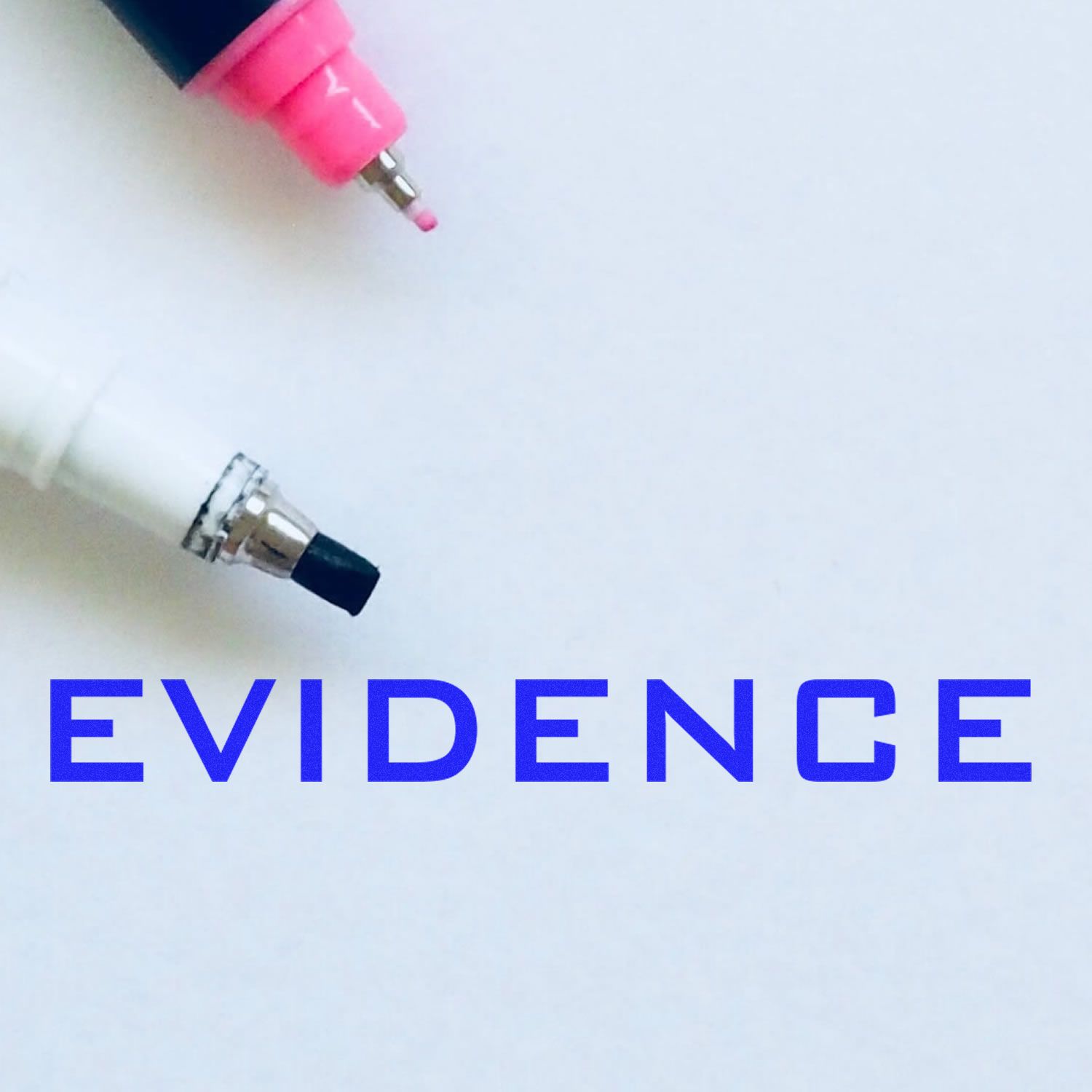 Large Pre-Inked Evidence Stamp in blue ink on white paper, with two markers, one pink and one white, positioned above the stamped text.