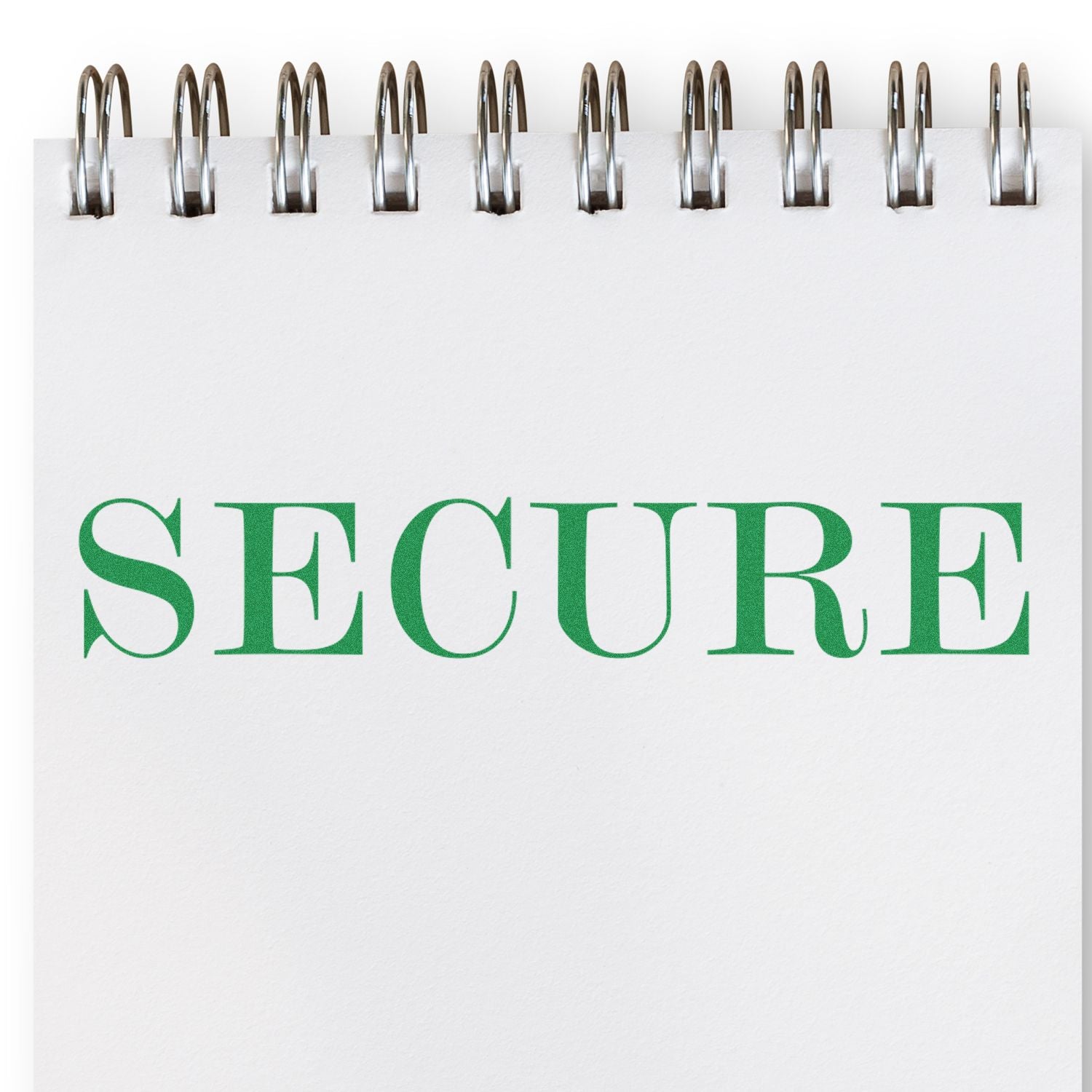 A Large Pre-Inked Secure Stamp imprint in green ink on a white notepad with a spiral binding.