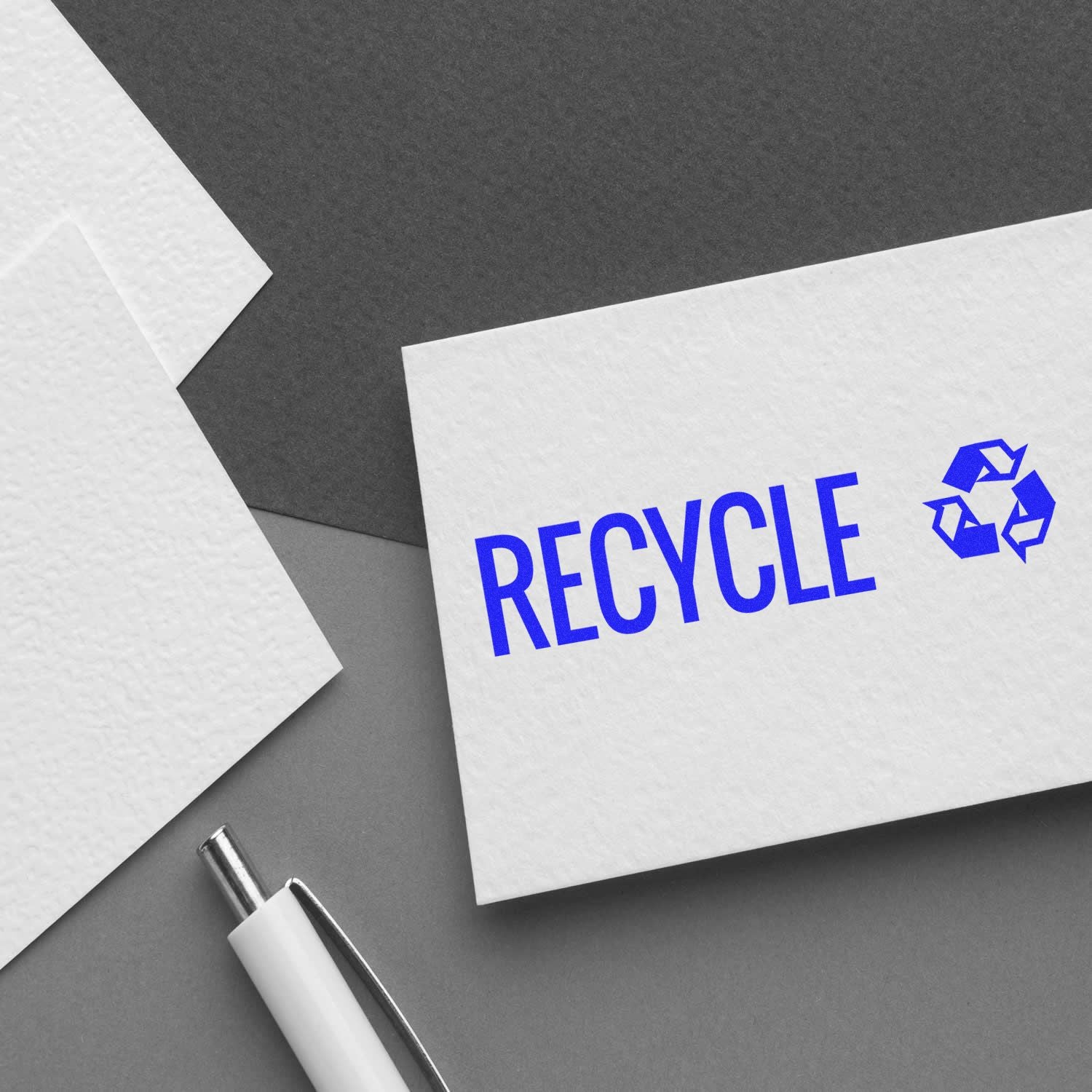 Large Pre-Inked Recycle with Logo Stamp on a white card, featuring the word 'RECYCLE' in blue with a recycling symbol, next to a pen.