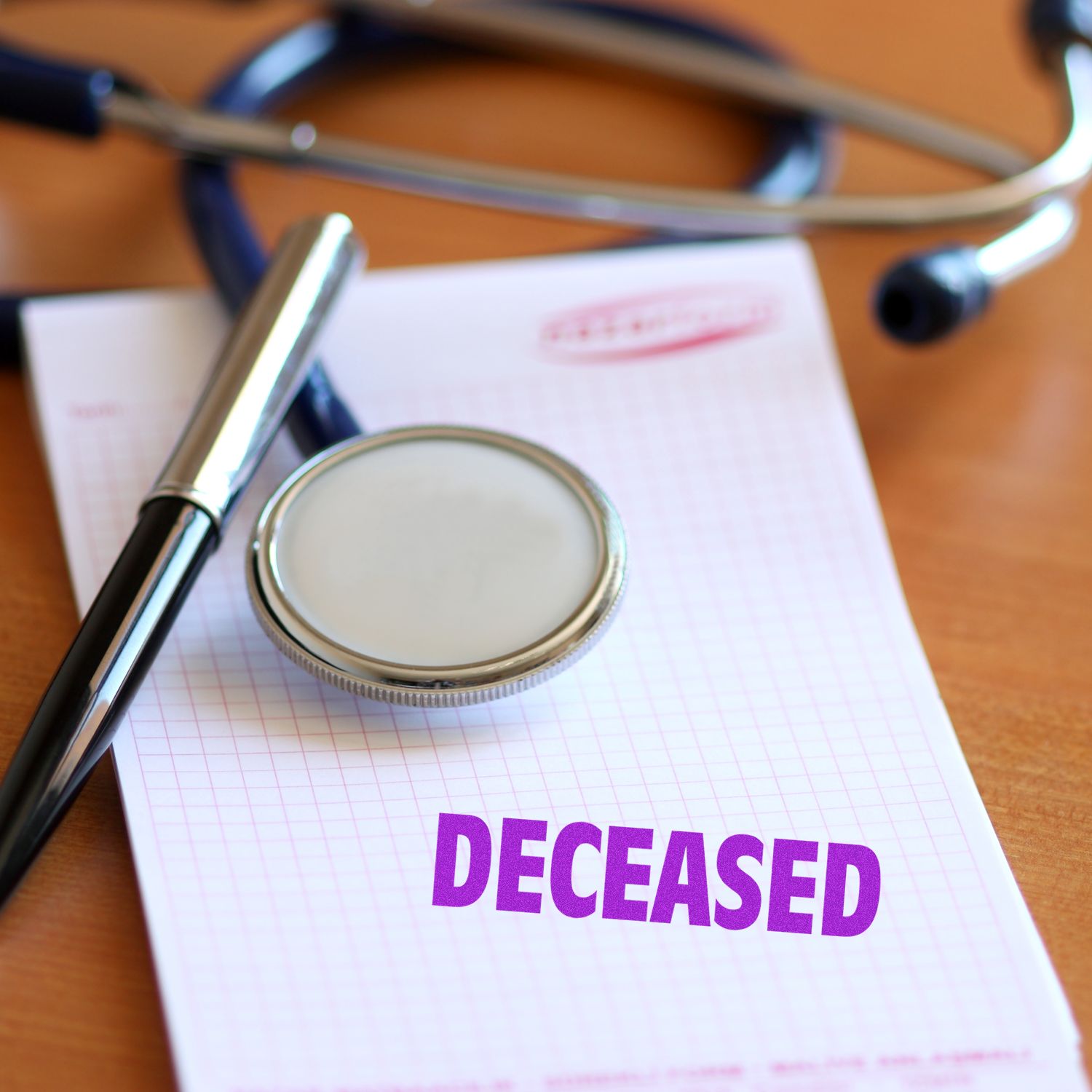 Large Pre-Inked Deceased Stamp in purple ink on a notepad, with a stethoscope and pen placed on a wooden surface.