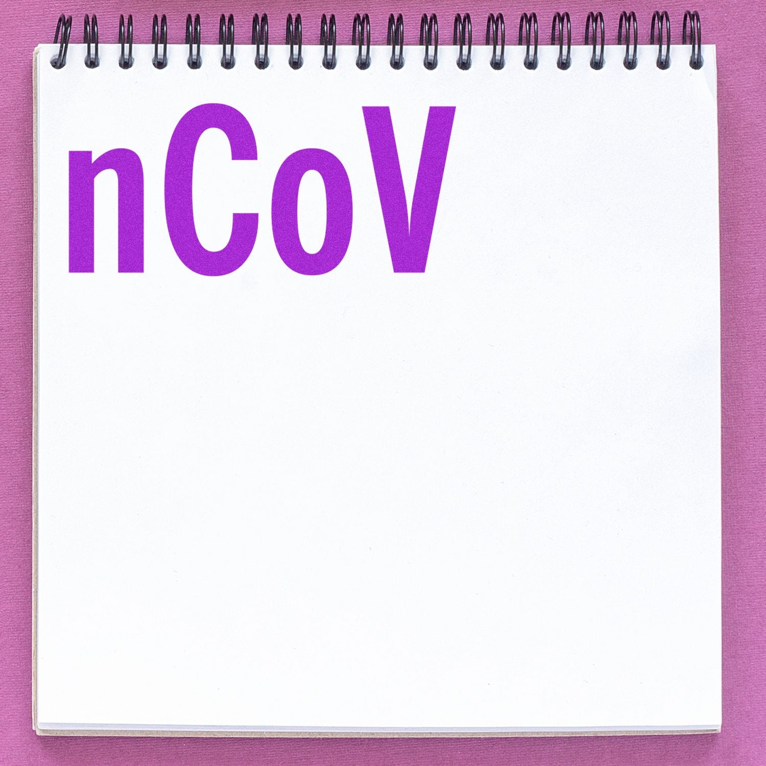 A notebook with nCoV stamped in purple using the Large Self Inking nCov Stamp, placed on a pink surface.