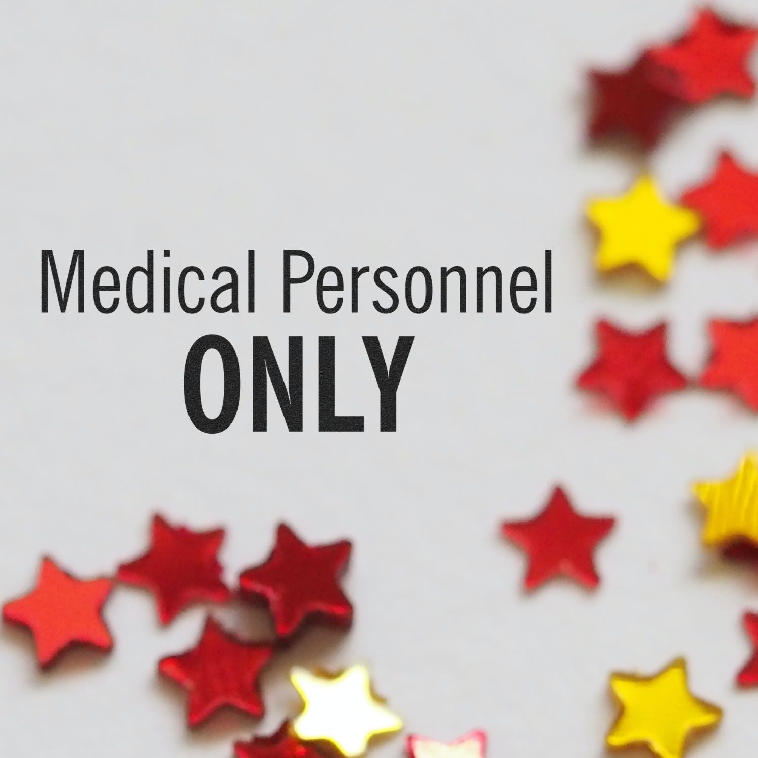 Image of a Large Self Inking Medical Personnel Only Stamp with red and yellow star confetti scattered around.