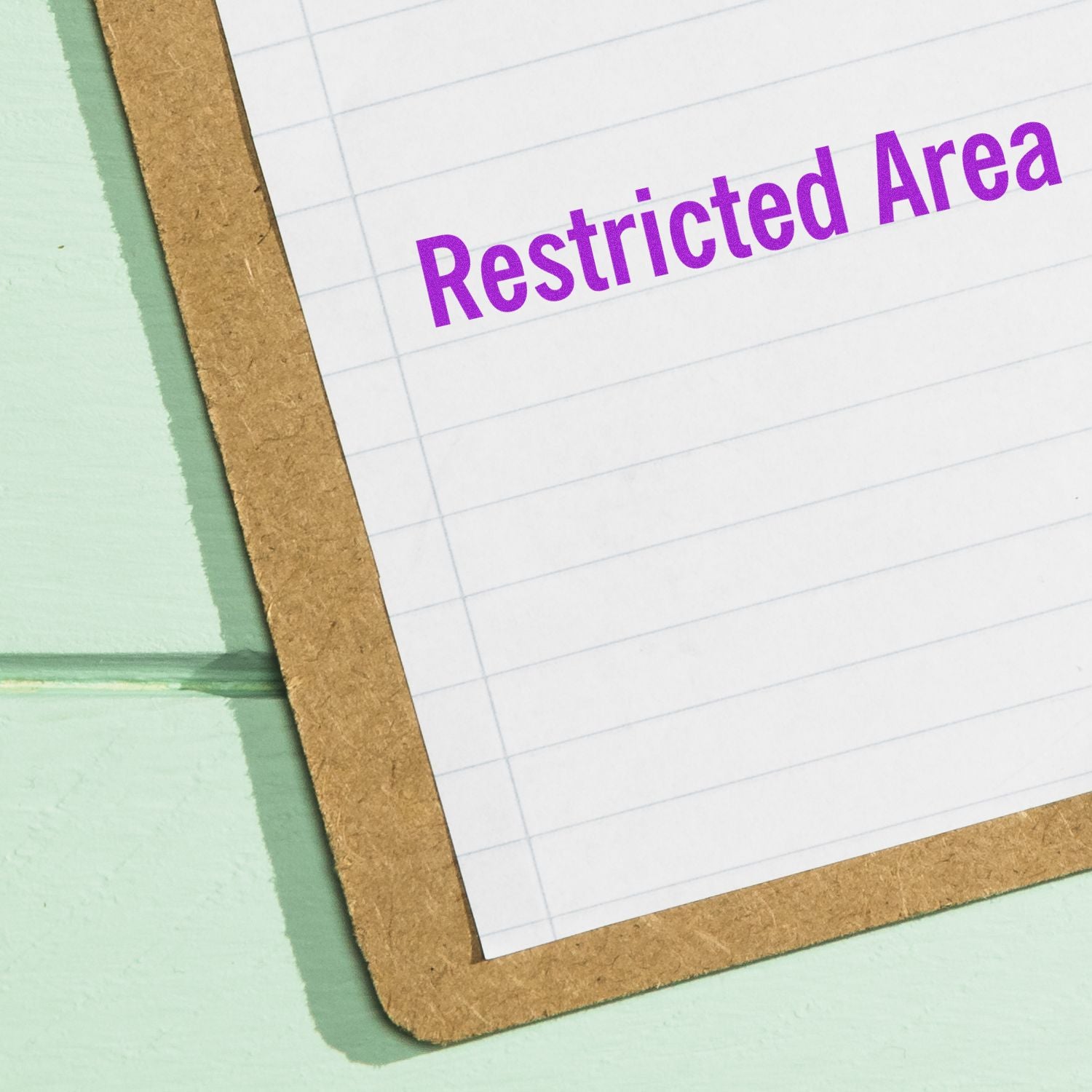 Large Self Inking Restricted Area Stamp imprint on a lined paper clipboard, showing clear and bold purple text.