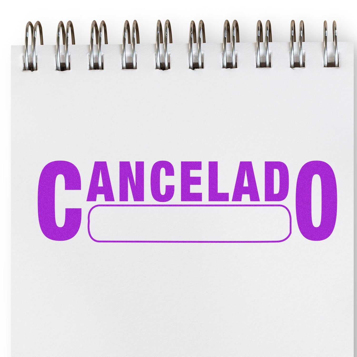 Large Self Inking Cancelado with Box Stamp in purple ink on a white spiral notebook.