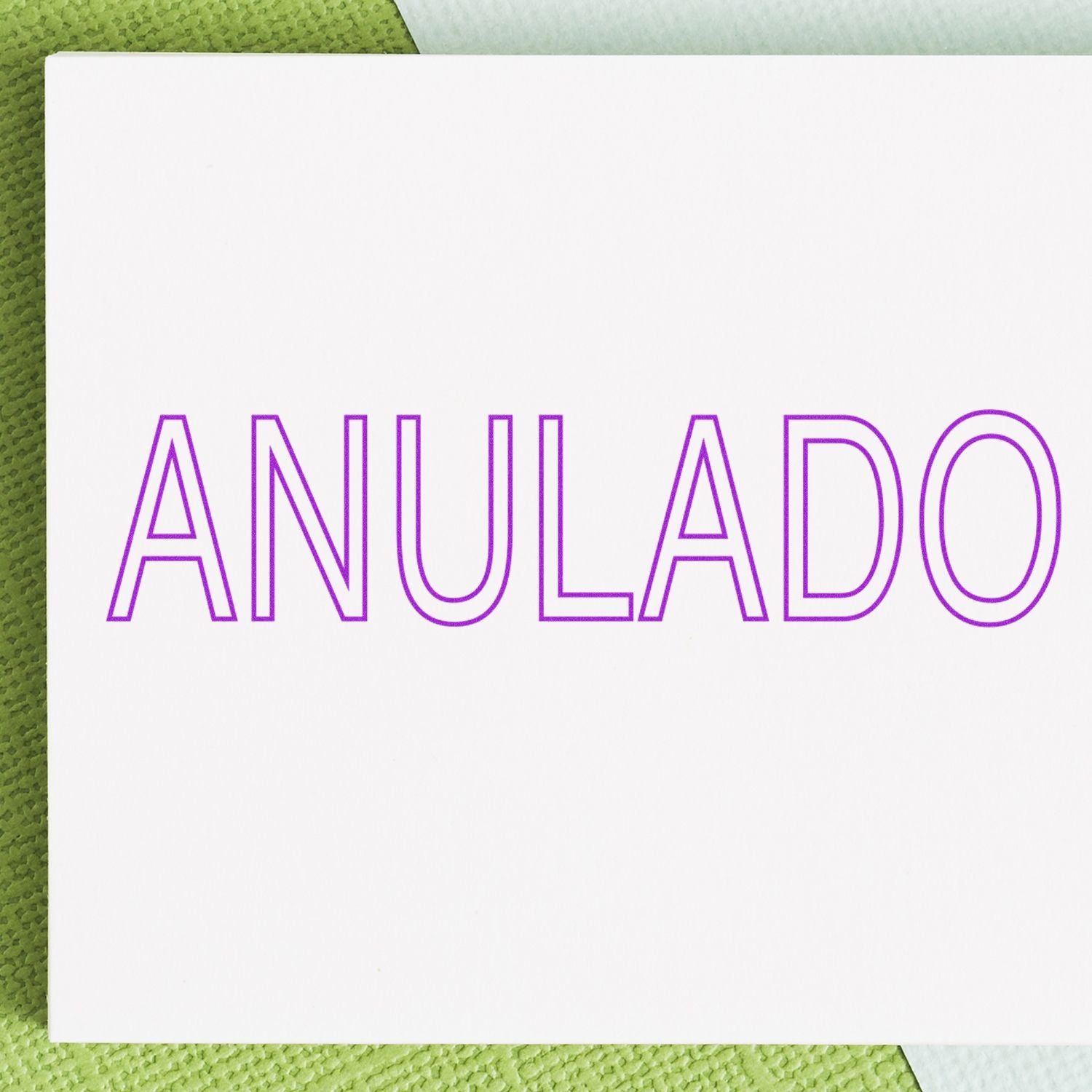 Large Self Inking Outline Anulado Stamp with purple text on a white background, placed on a green and white textured surface.