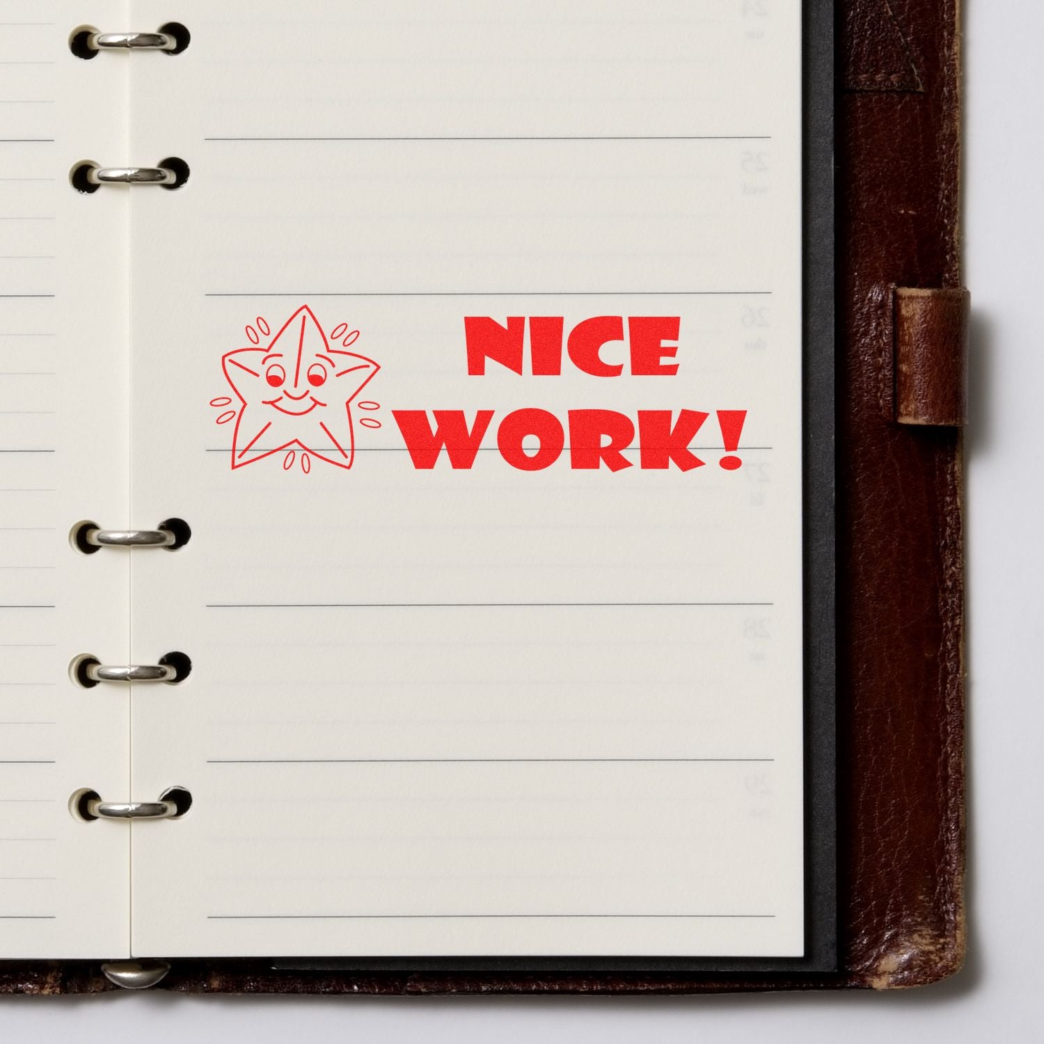 Large Pre-Inked Nice Work Stamp with a smiling star design stamped in red ink on a lined notebook page.