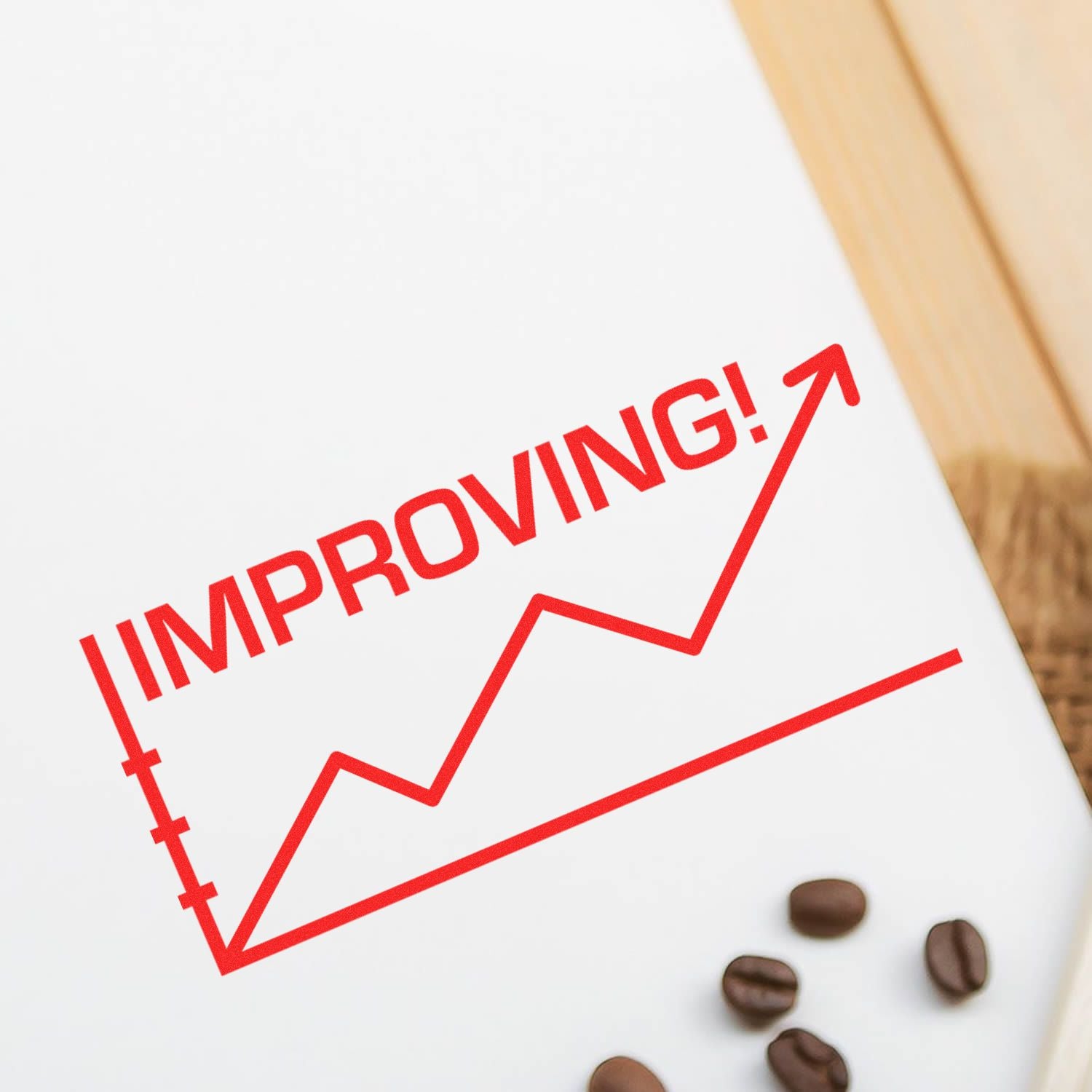 Large Pre-Inked Improving with Chart Icon Stamp showing a red upward trend line and the word IMPROVING! on a white surface with coffee beans nearby.