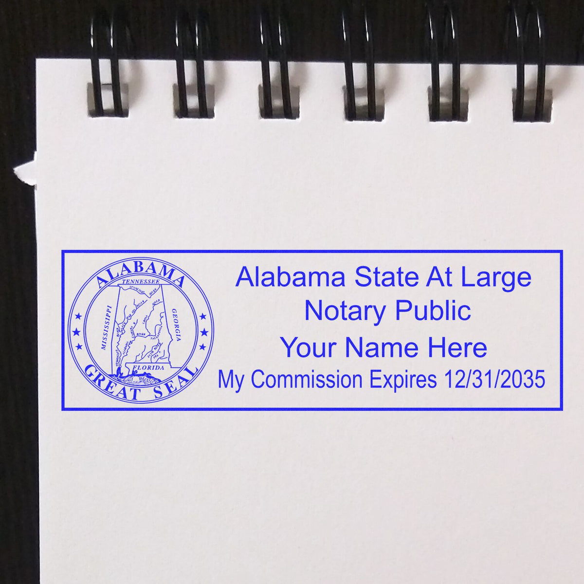 An alternative view of the Super Slim Alabama Notary Public Stamp stamped on a sheet of paper showing the image in use