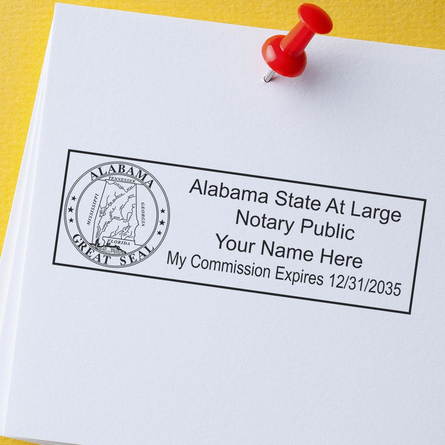 Wood Handle Alabama State Seal Notary Public Stamp on white paper with red pushpin, showing customizable notary public information and expiration date.