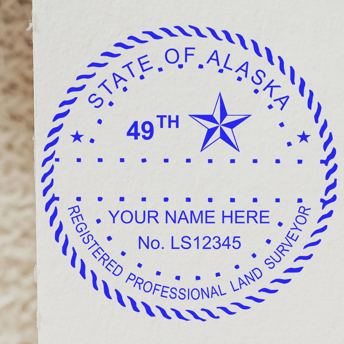 A lifestyle photo showing a stamped image of the Slim Pre-Inked Alaska Land Surveyor Seal Stamp on a piece of paper