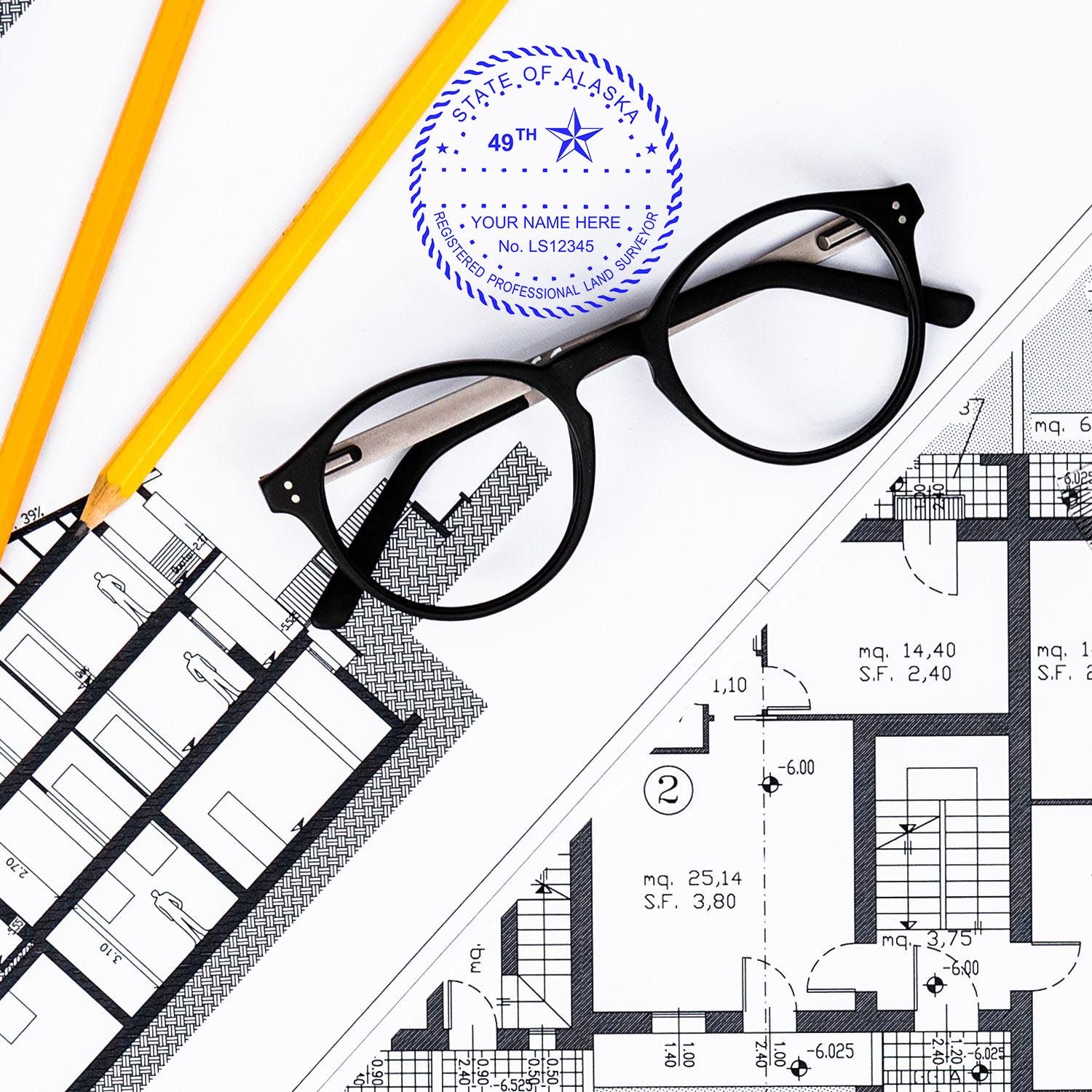 Premium MaxLight Pre-Inked Alaska Surveyors Stamp on architectural plans with glasses and pencils nearby.