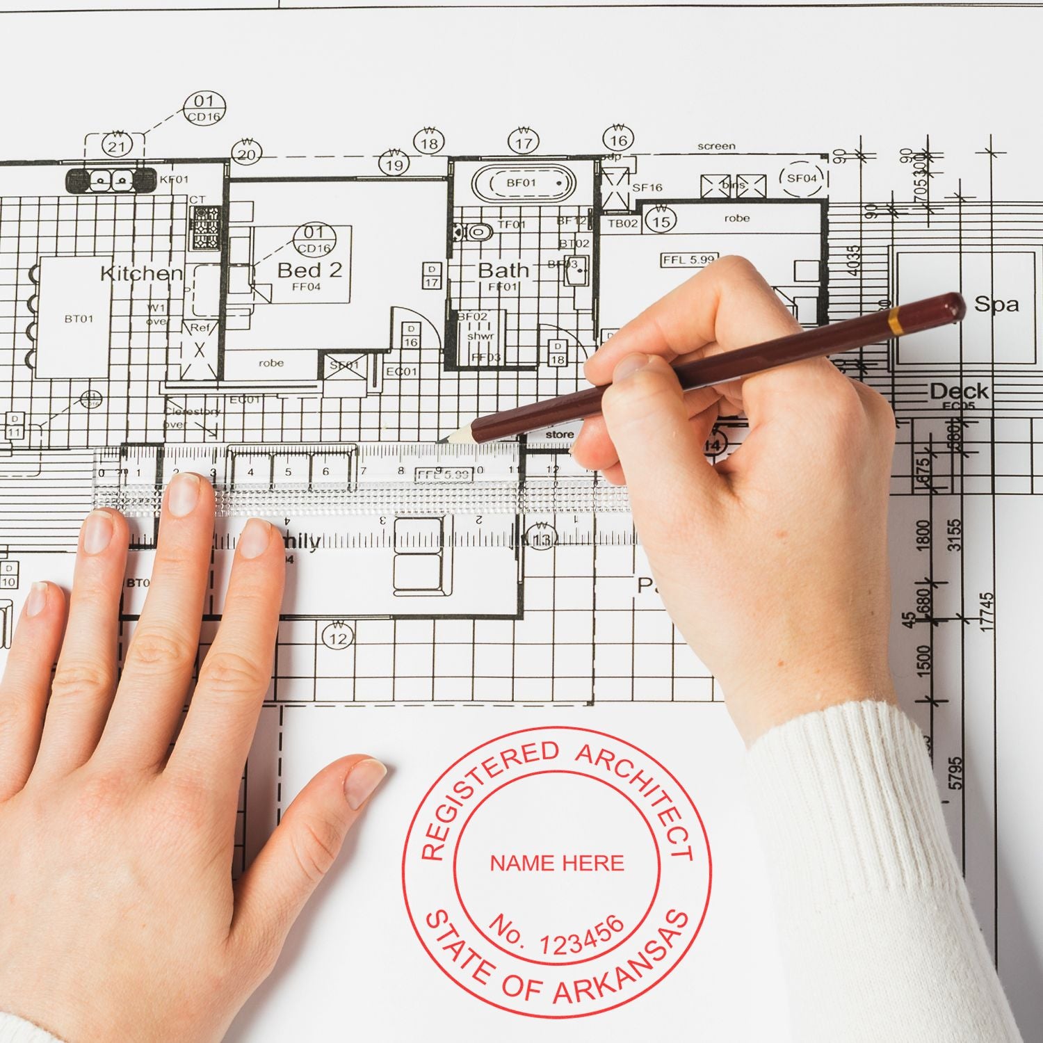 Hands using a pen on a blueprint with an Arkansas Architect Seal Stamp visible, labeled Registered Architect, State of Arkansas.