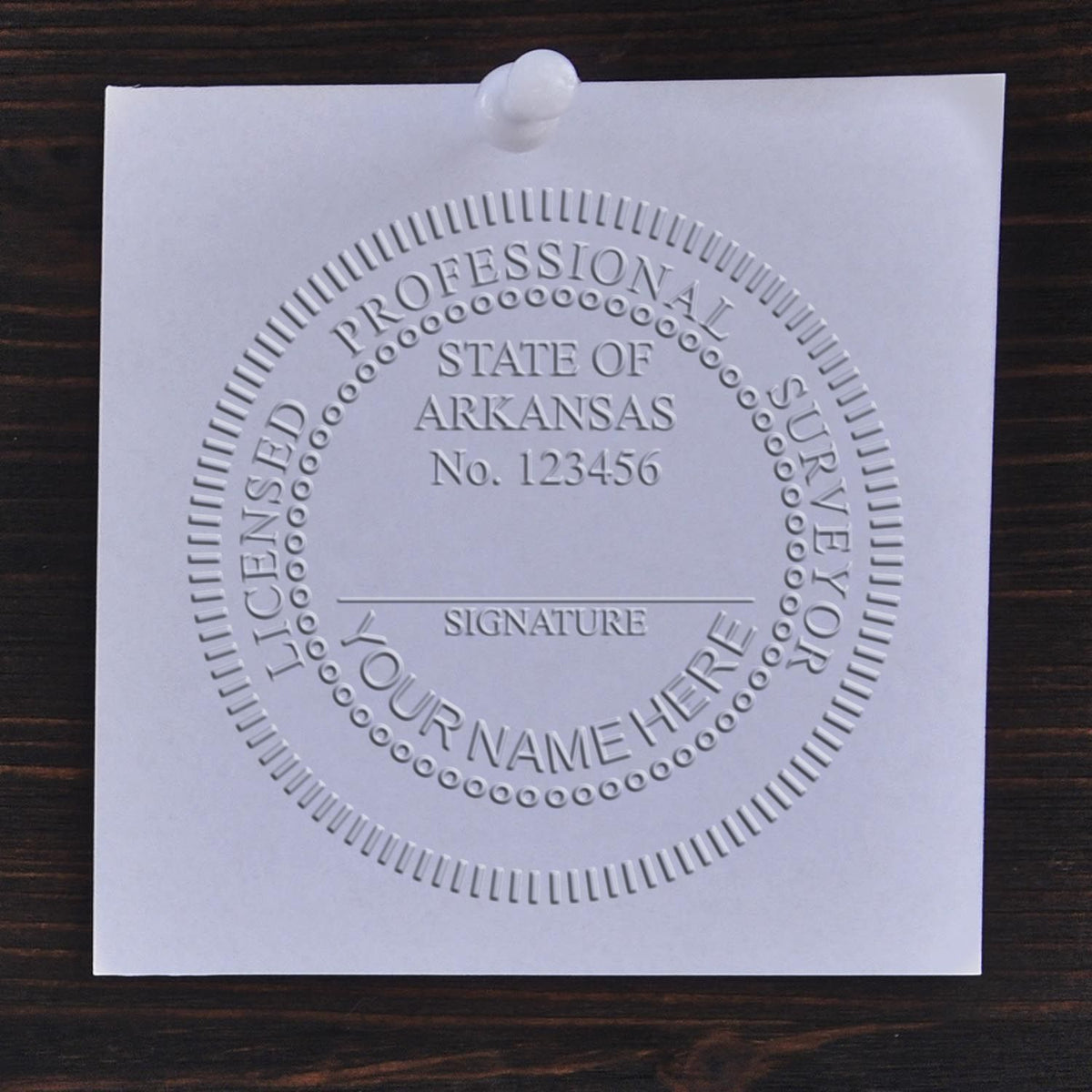 A photograph of the State of Arkansas Soft Land Surveyor Embossing Seal stamp impression reveals a vivid, professional image of the on paper.
