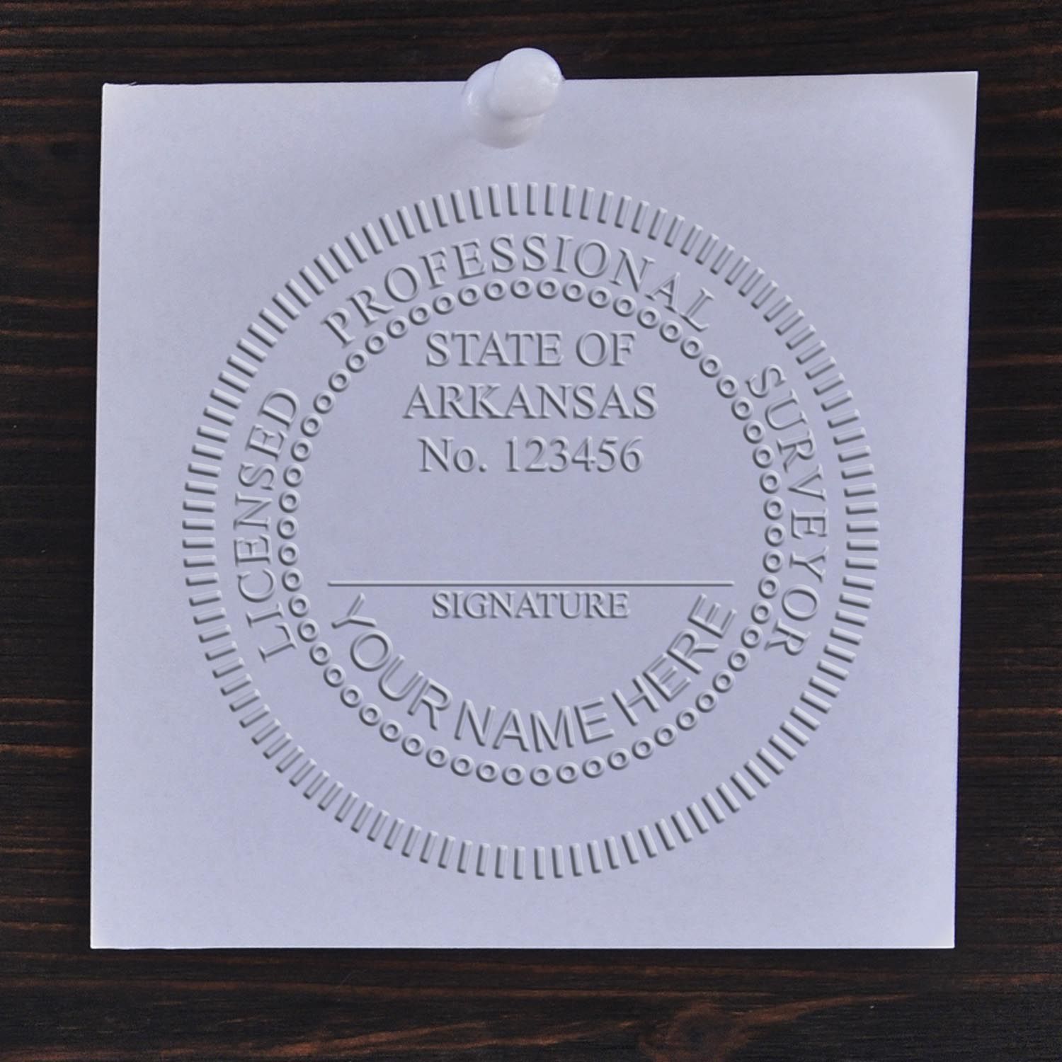The main image for the Arkansas Desk Surveyor Seal Embosser depicting a sample of the imprint and electronic files