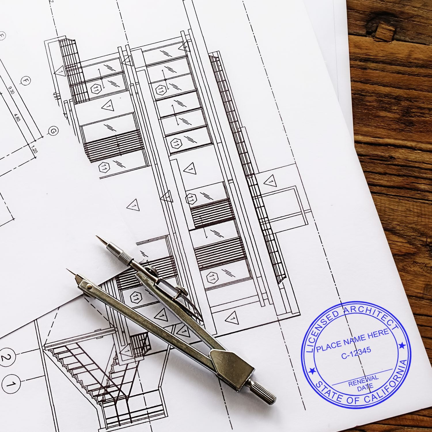 Architectural plans with a Premium MaxLight Pre-Inked California Architectural Stamp, compass, and ruler on a wooden table.