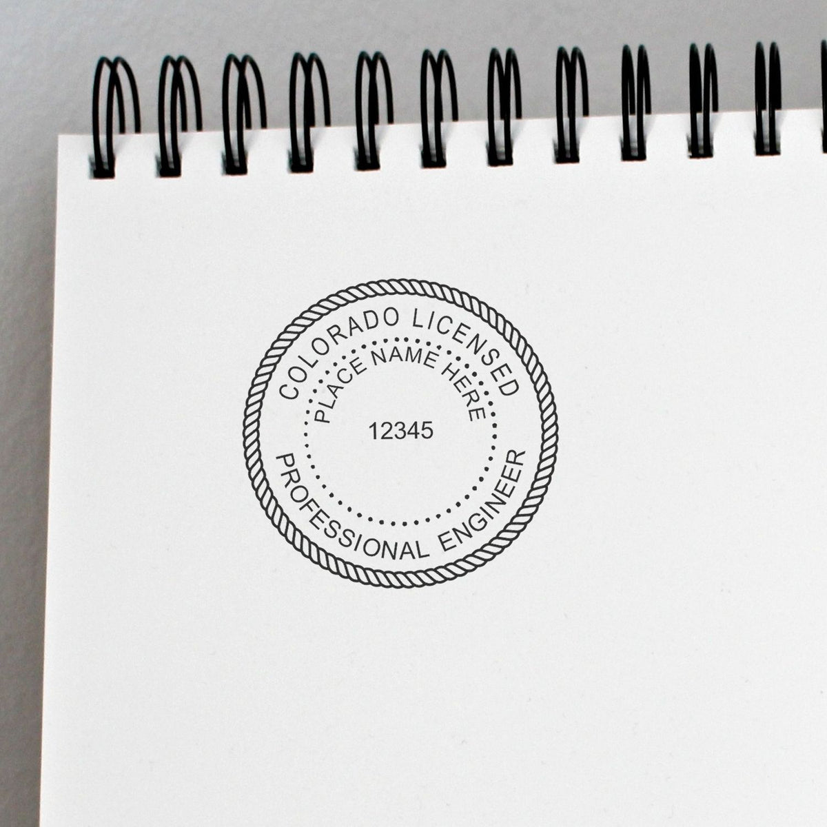 A stamped impression of the Colorado Professional Engineer Seal Stamp in this stylish lifestyle photo, setting the tone for a unique and personalized product.