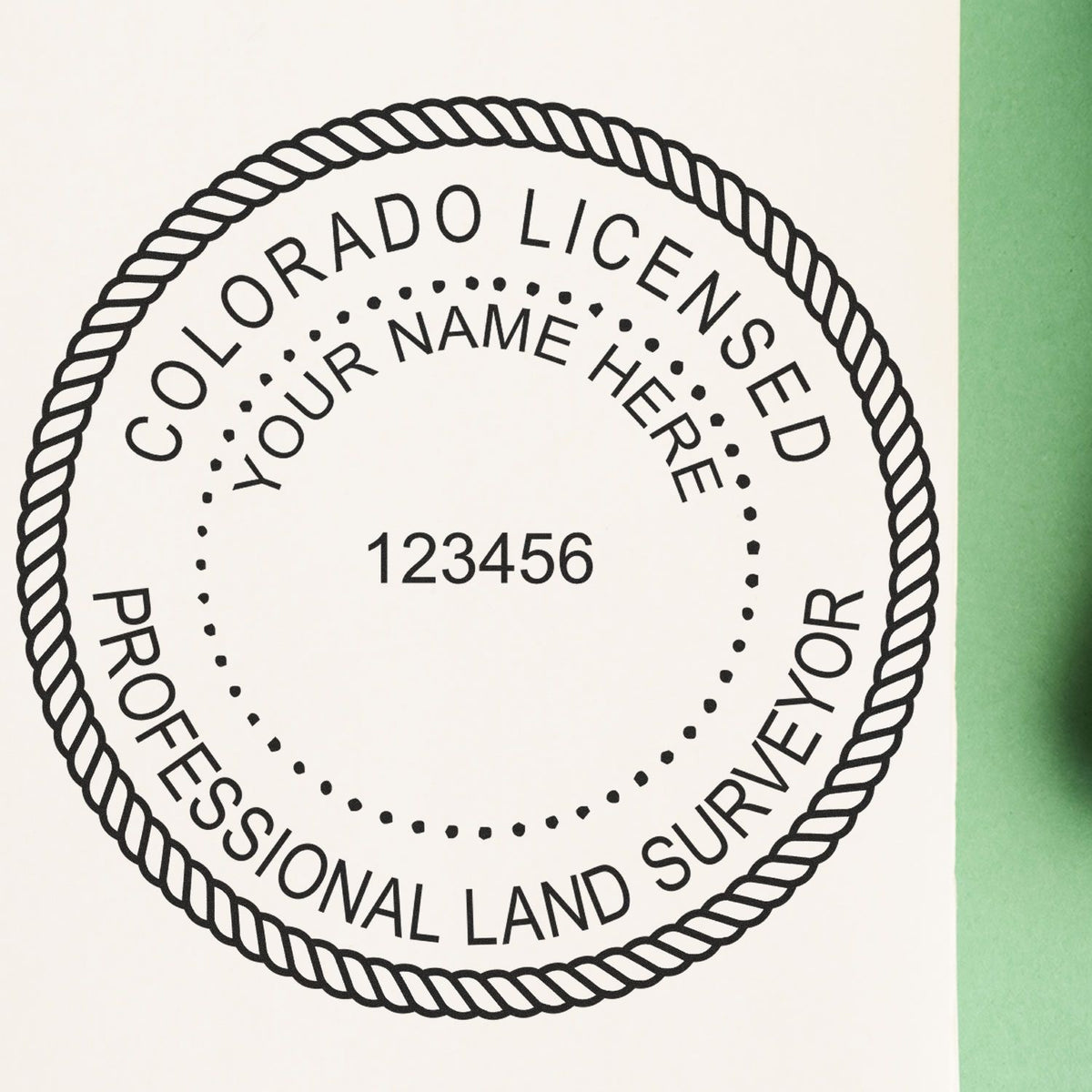 A lifestyle photo showing a stamped image of the Slim Pre-Inked Colorado Land Surveyor Seal Stamp on a piece of paper
