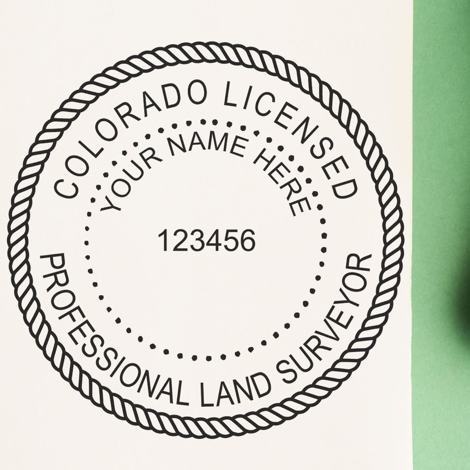 Self Inking Colorado Land Surveyor Stamp with customizable name and license number, displayed on white paper with green background.