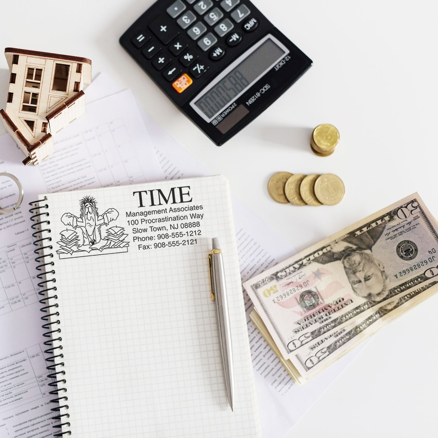 Custom Rubber Stamp Size 3 x 5 used on a notebook with a pen, calculator, coins, cash, and papers in the background.