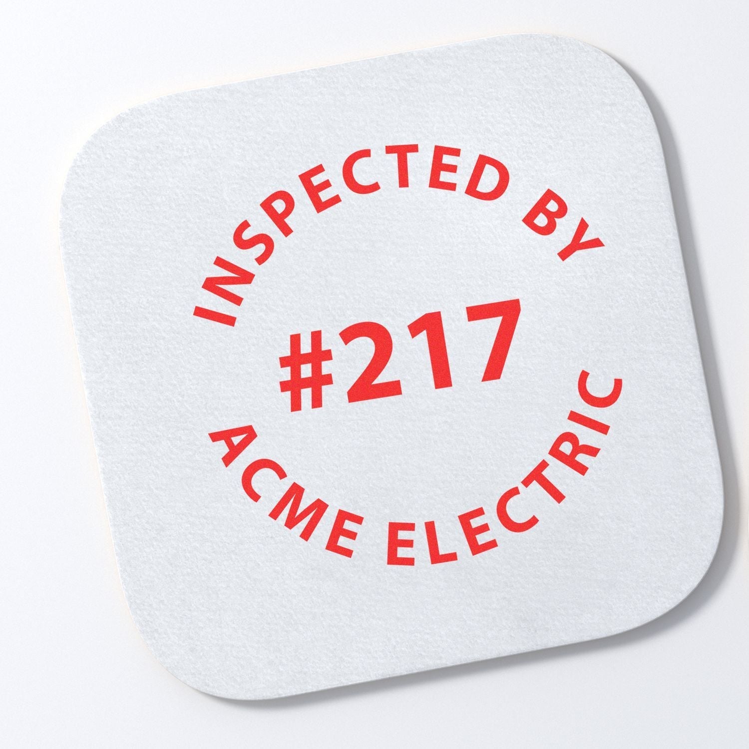 Custom Rubber Stamp Size 1 Inch Diameter with red text INSPECTED BY #217 ACME ELECTRIC on a white square paper.