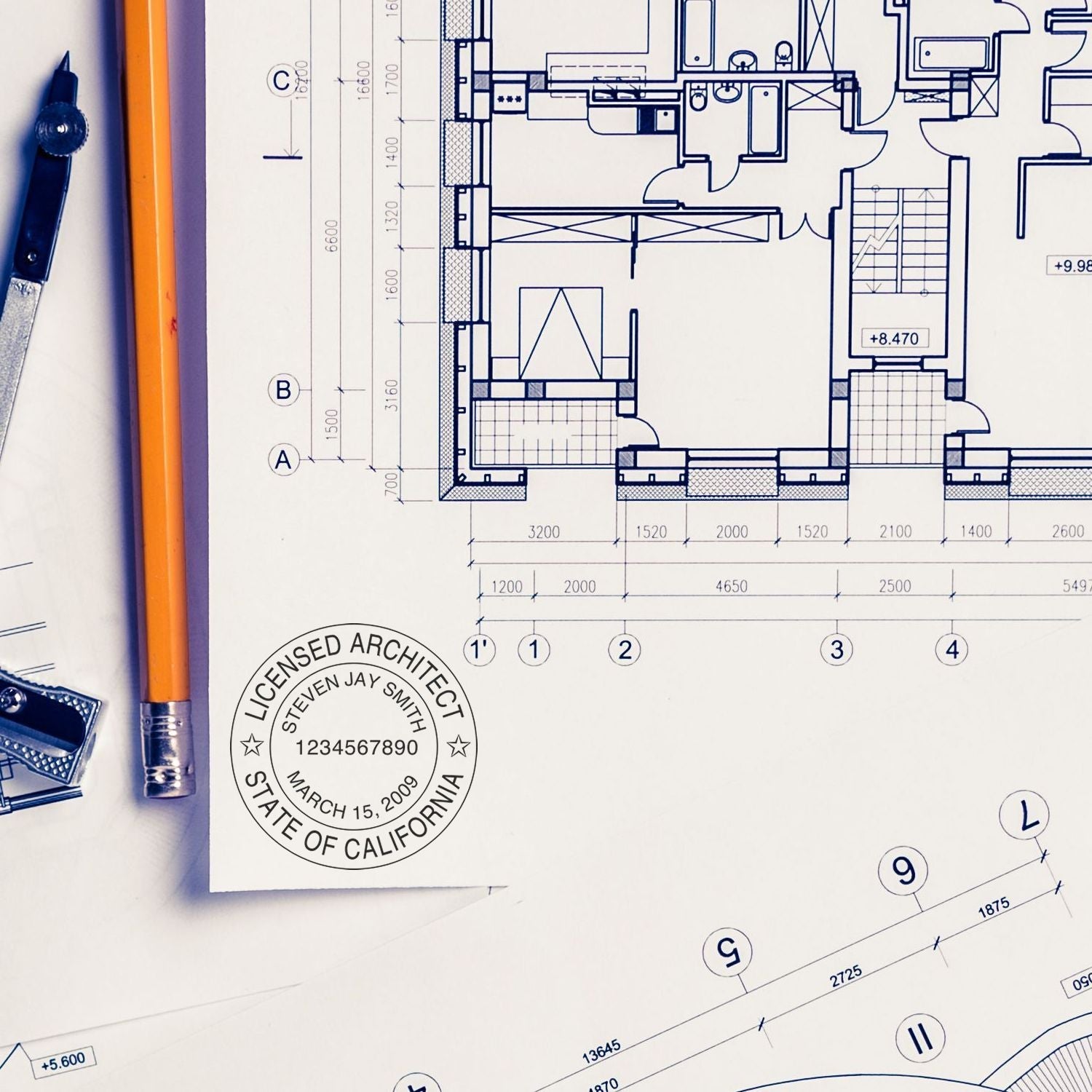 Architectural blueprint stamped with Custom Self Inking Stamp Trodat 4638 Size 1-1/2 Diameter, surrounded by drafting tools and a pencil.