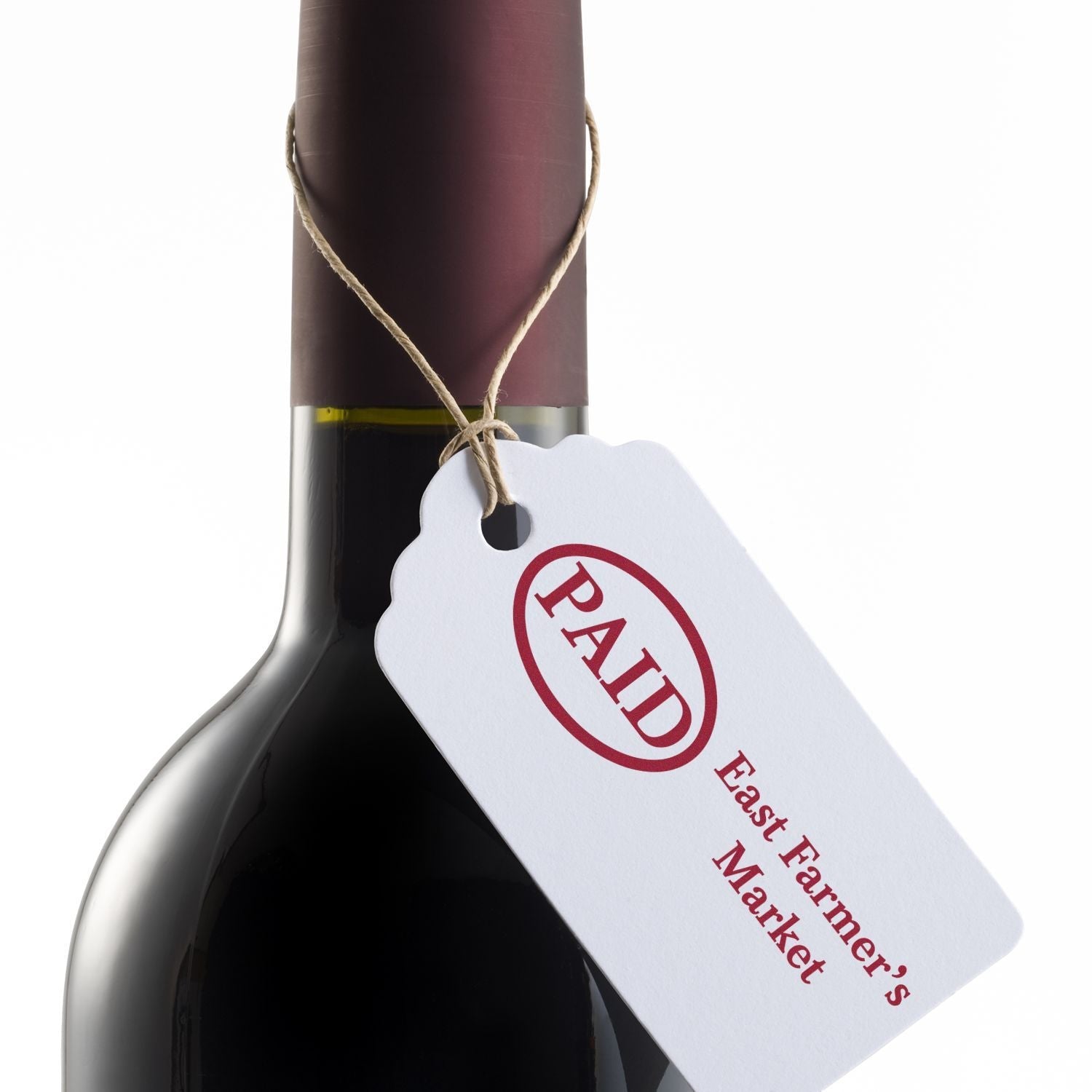 A wine bottle with a tag stamped PAID using the Custom Self Inking Rubber Stamp Trodat 4914 Size 1 x 2-1/2.