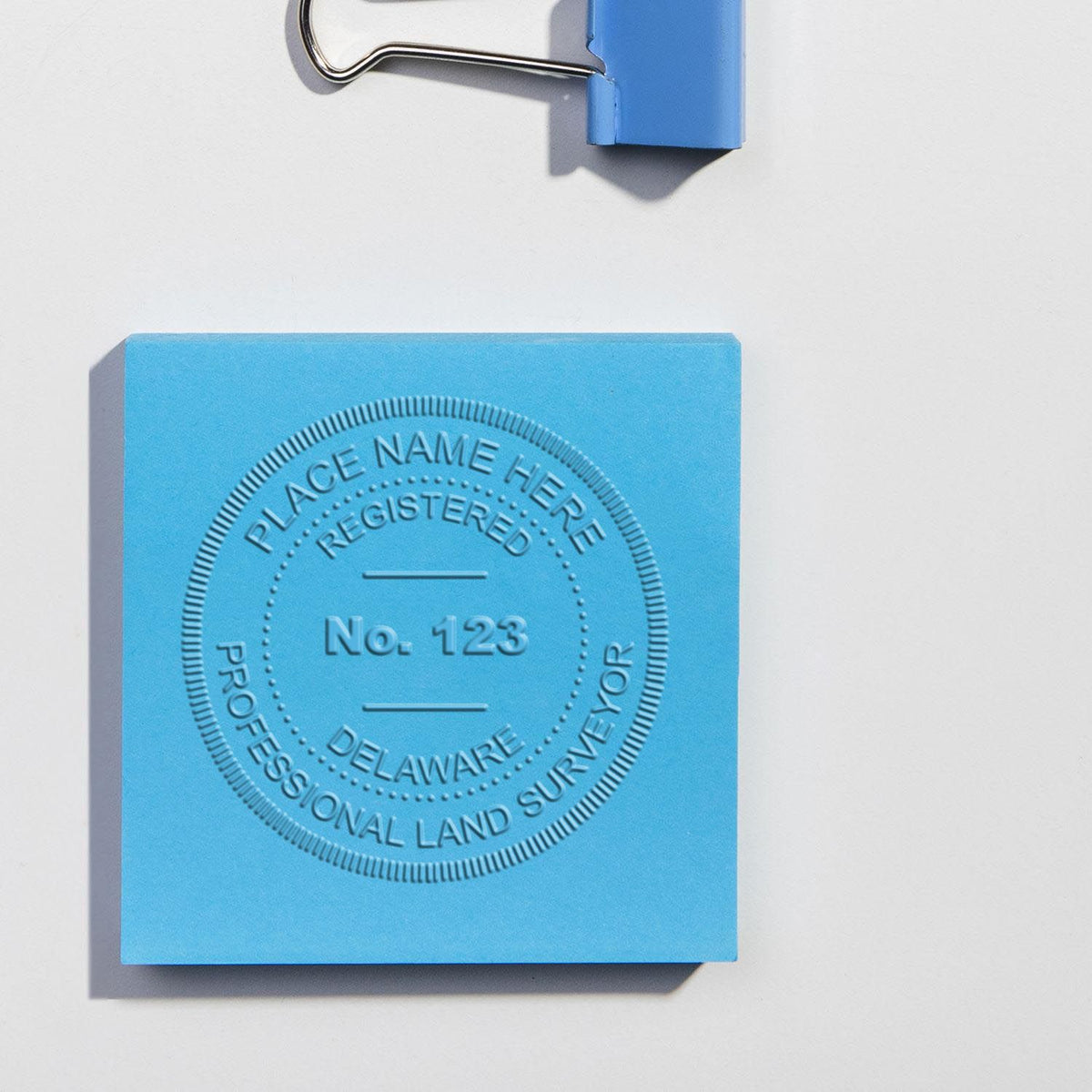 An in use photo of the Gift Delaware Land Surveyor Seal showing a sample imprint on a cardstock