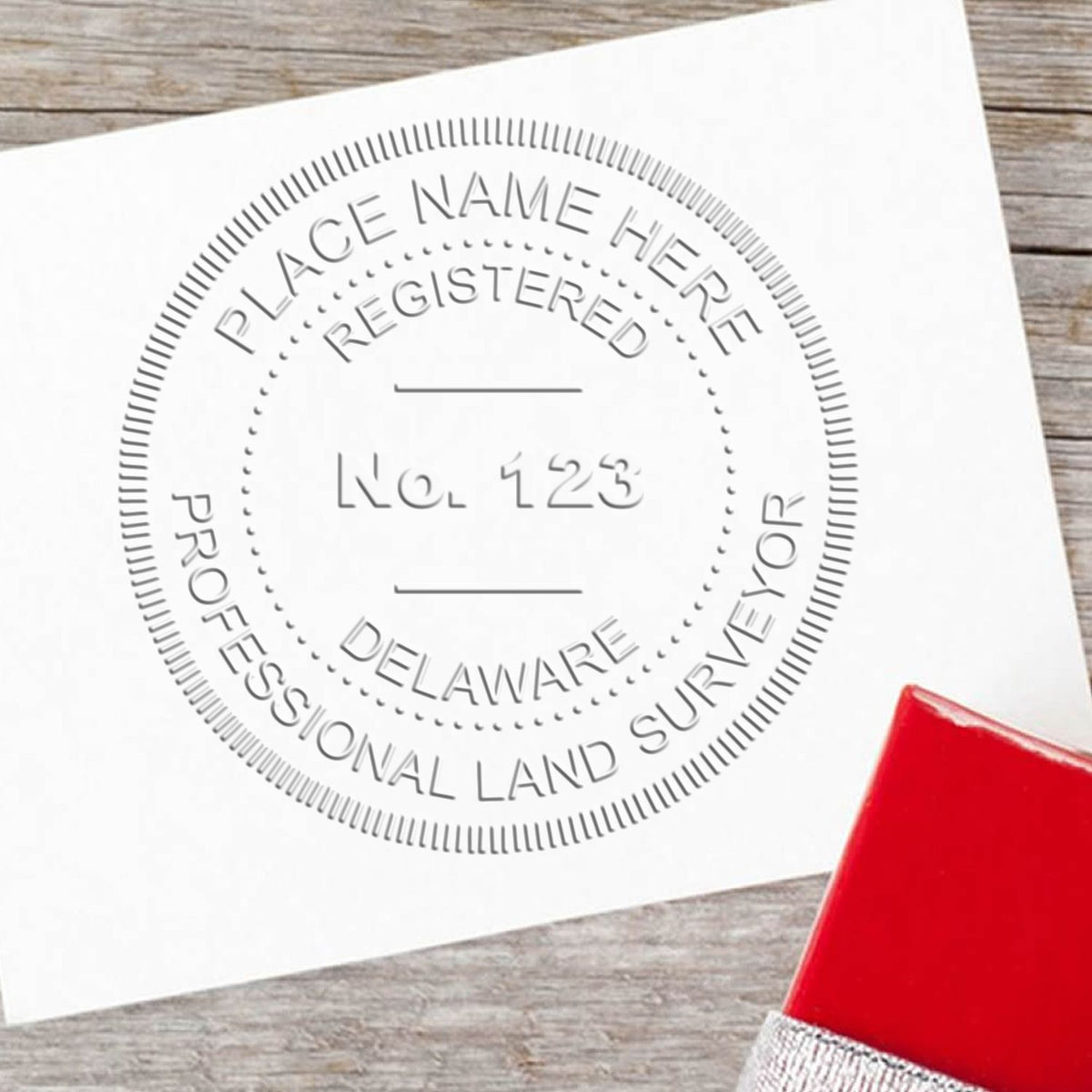 A lifestyle photo showing a stamped image of the State of Delaware Soft Land Surveyor Embossing Seal on a piece of paper