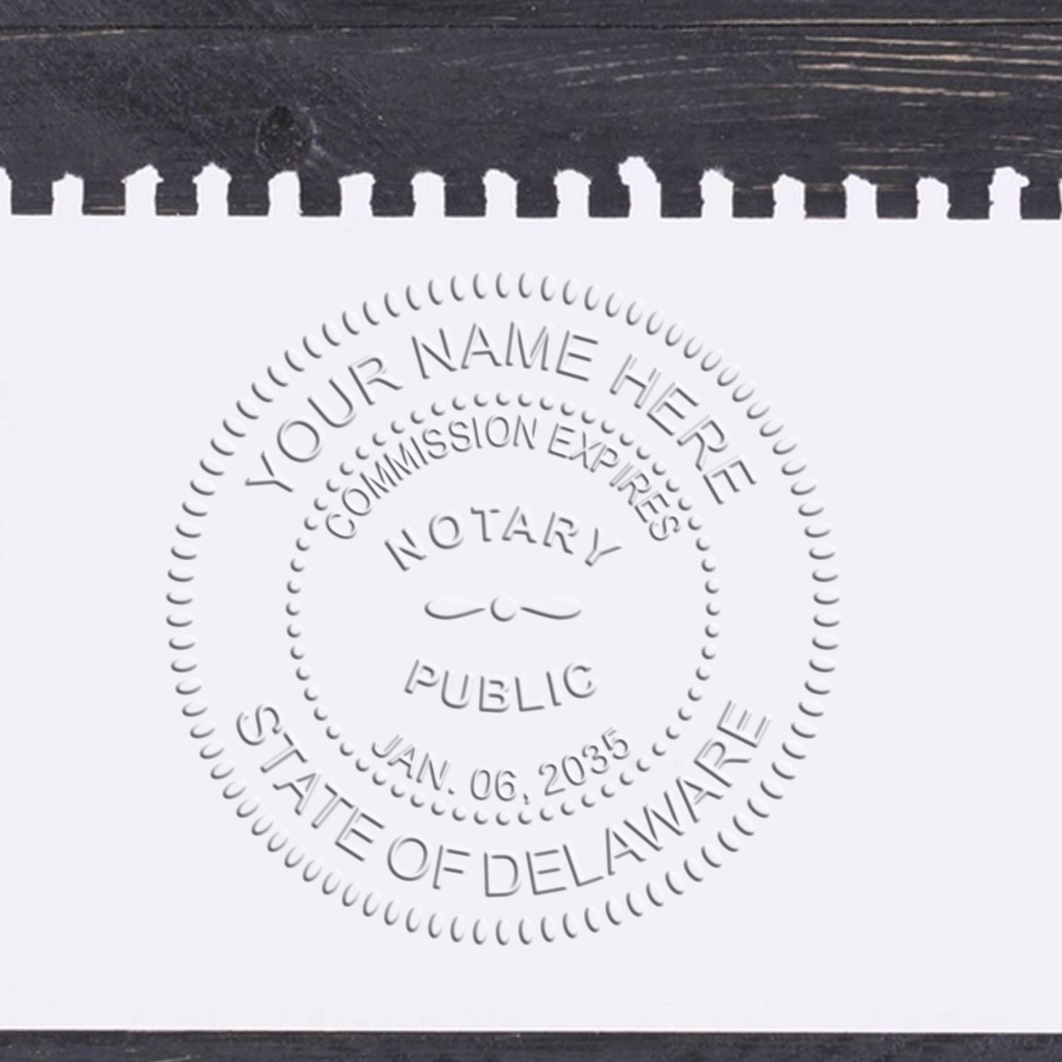 A lifestyle photo showing a stamped image of the Delaware Handheld Notary Seal Embosser on a piece of paper