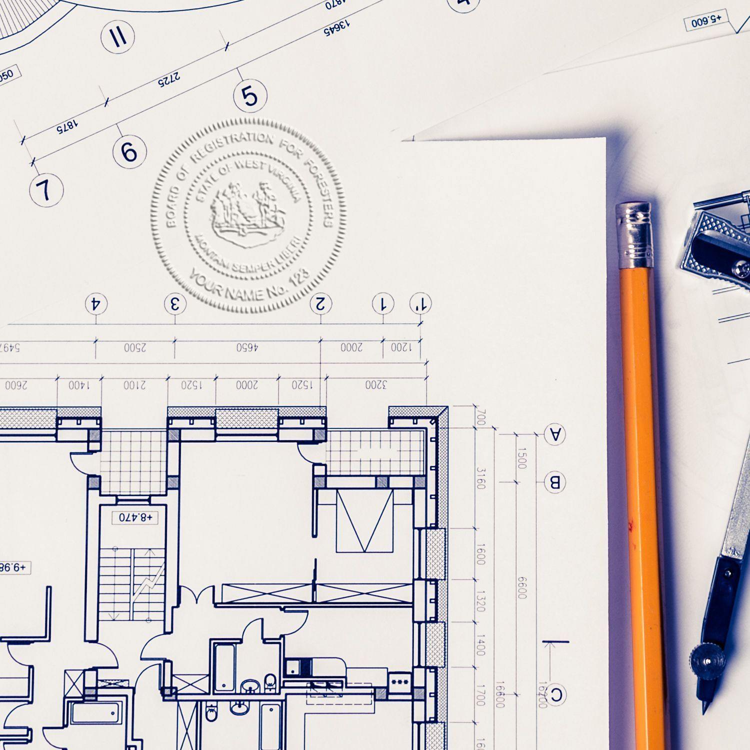 Forester Handheld Seal Embosser in use on architectural blueprints, with a pencil and drafting tools nearby.