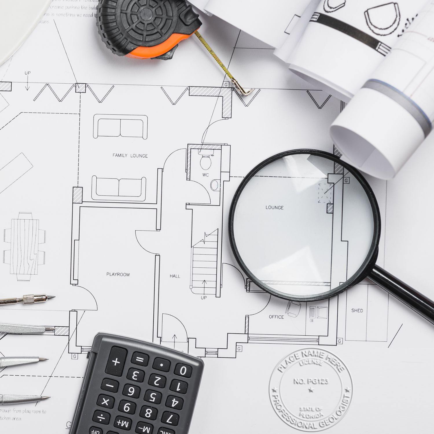 Geologist Handheld Seal Embosser in use on architectural blueprints, surrounded by a magnifying glass, calculator, and measuring tape.