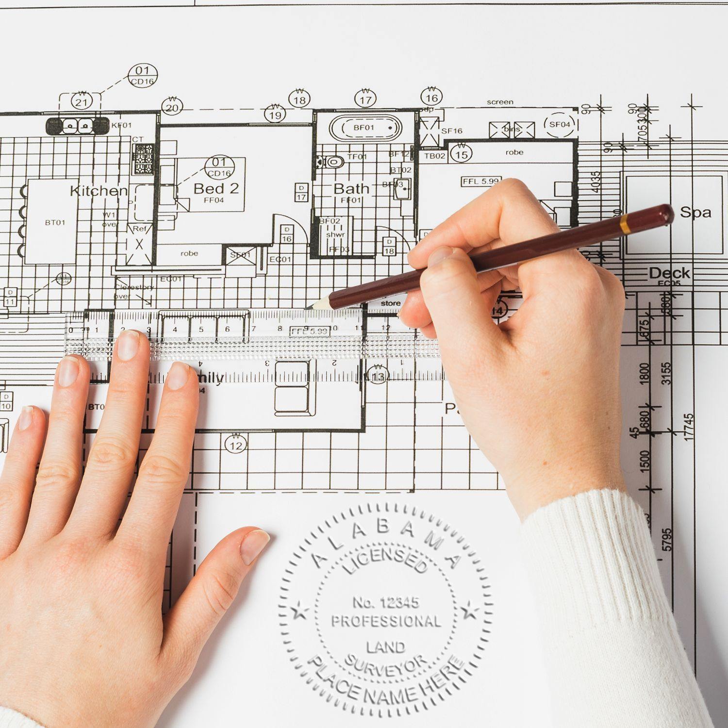 Hands using the Land Surveyor Pink Gift Embosser on a detailed architectural blueprint, creating a professional seal.