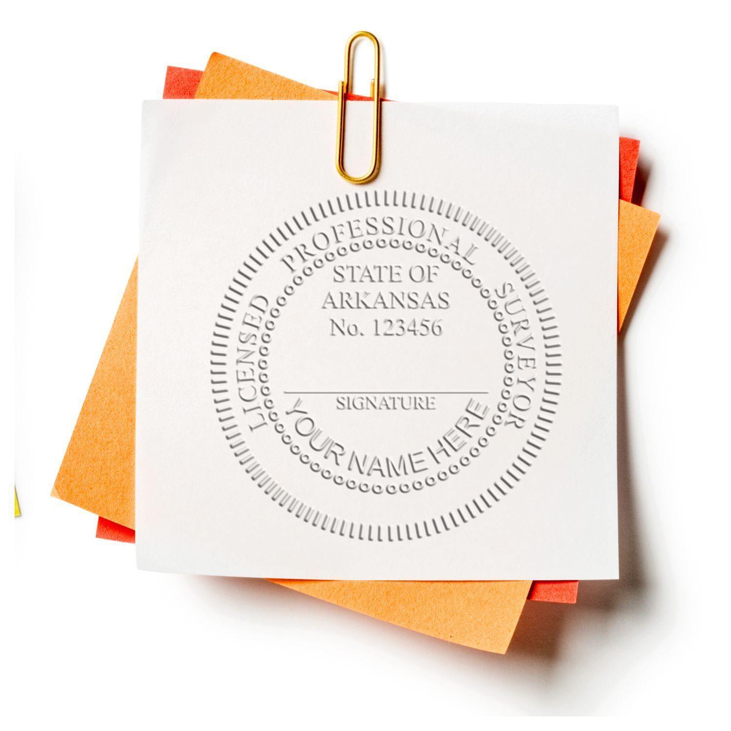 Land Surveyor Handheld Seal Embosser in use, creating a detailed embossed seal on a white paper clipped to orange and yellow papers.