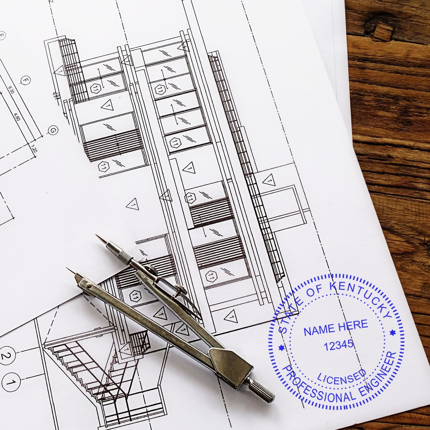 Blueprints on a wooden table with a compass and the Professional Engineer eSeal Electronic Image Stamp of Seal from the State of Kentucky, displaying Licensed Professional Engineer and placeholder text for name and number.